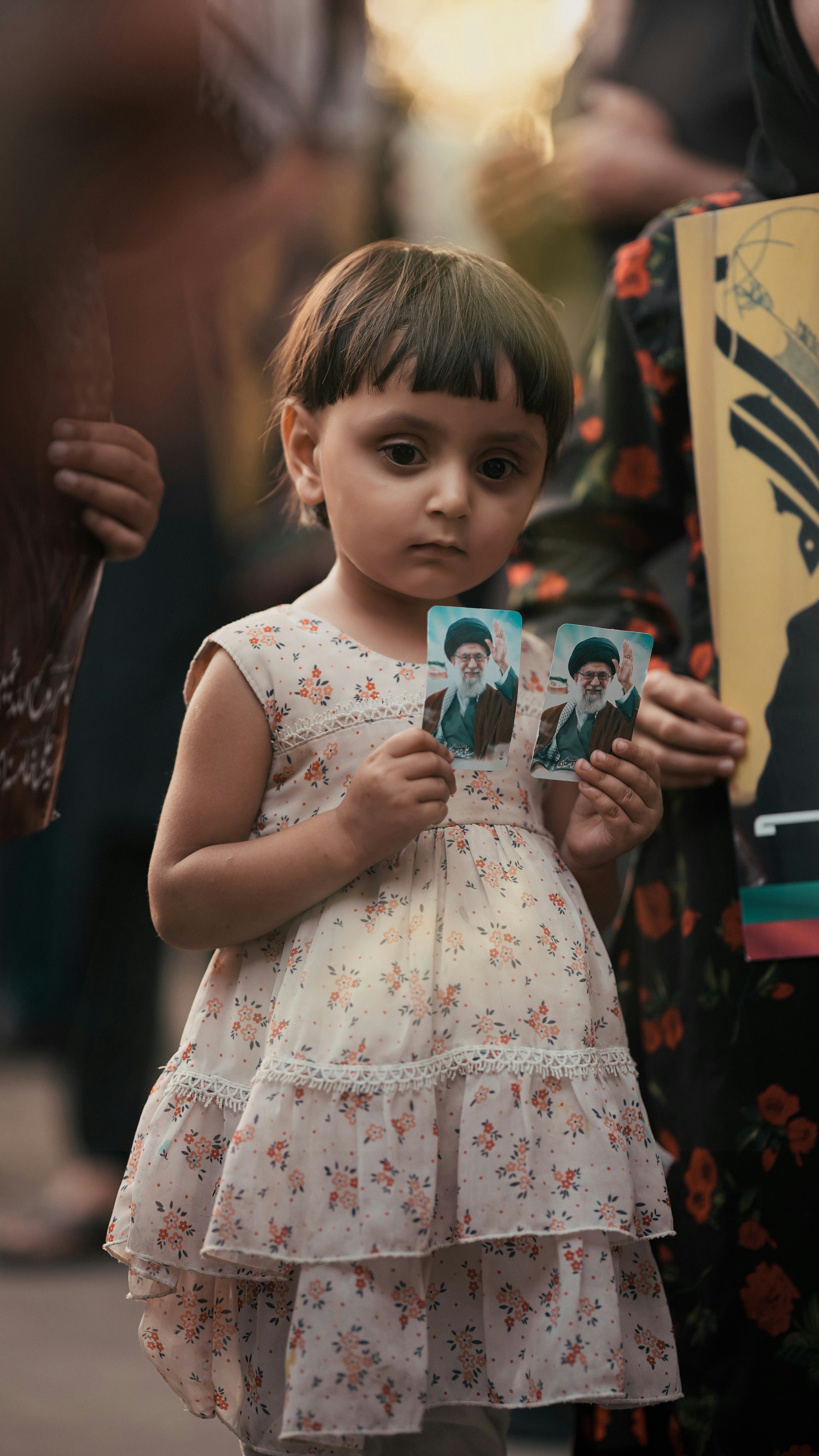 Young girl holds portraits of a man