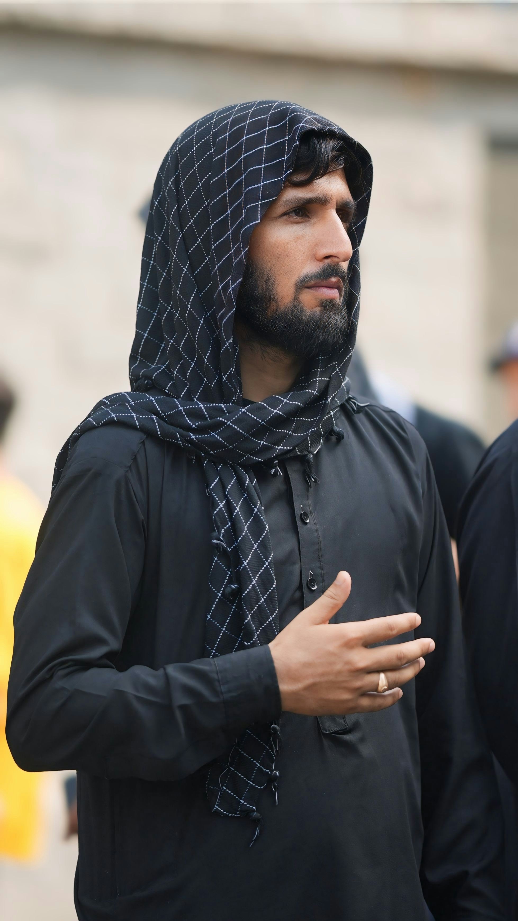 Homme vêtu de vêtements traditionnels noirs et foulard