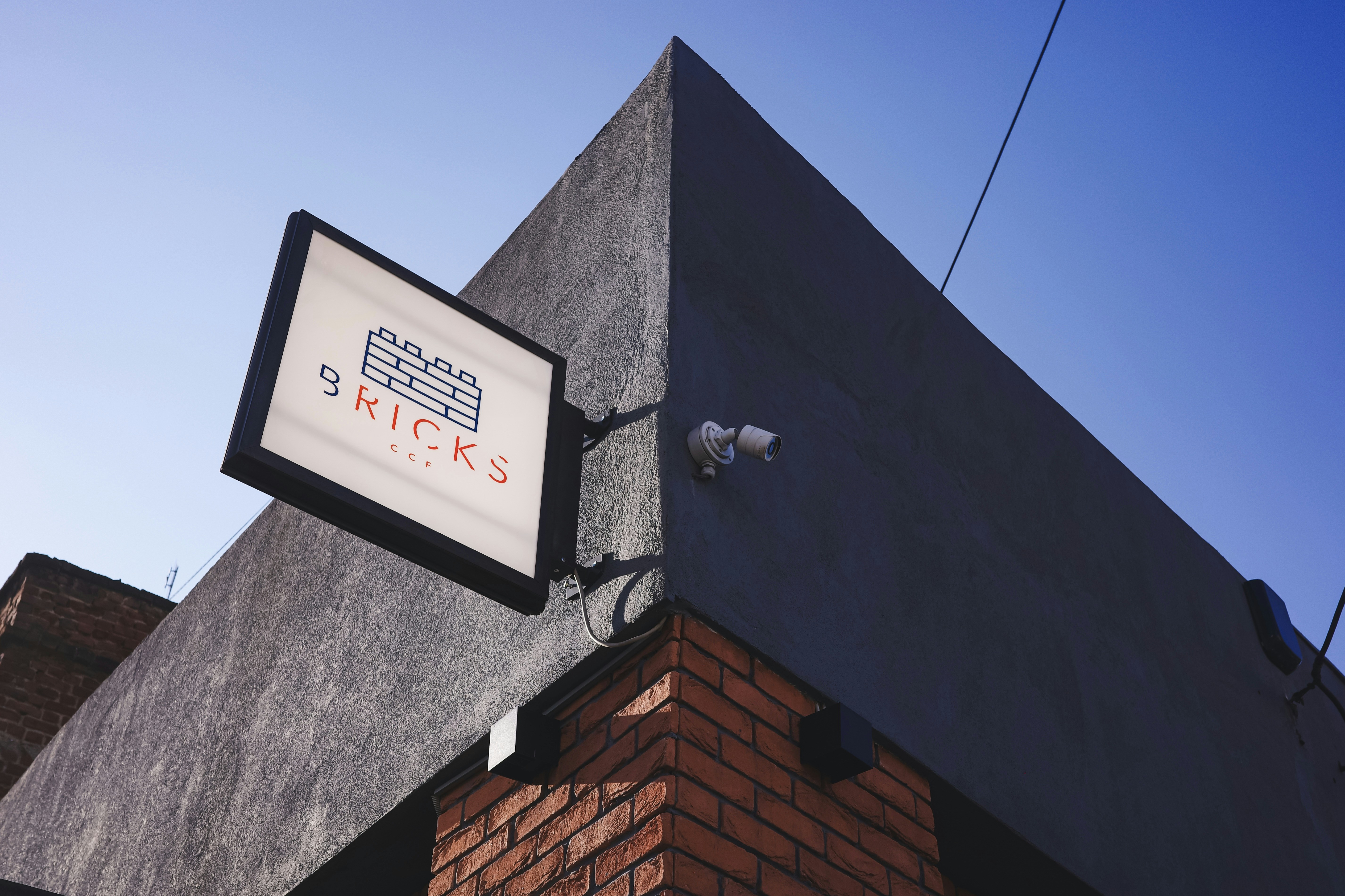 Building corner with illuminated sign and security camera