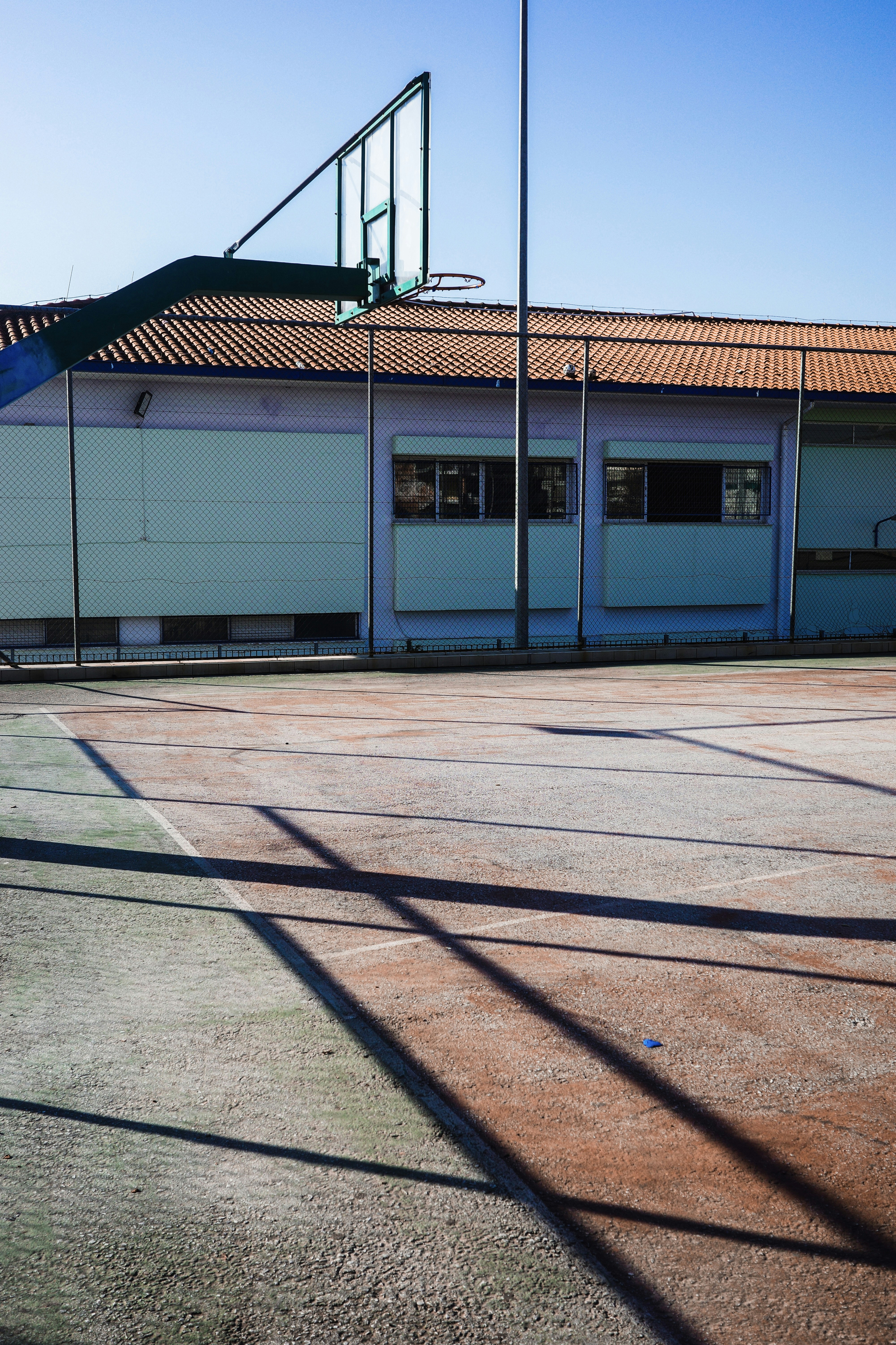 Outdoor basketball court with building in background
