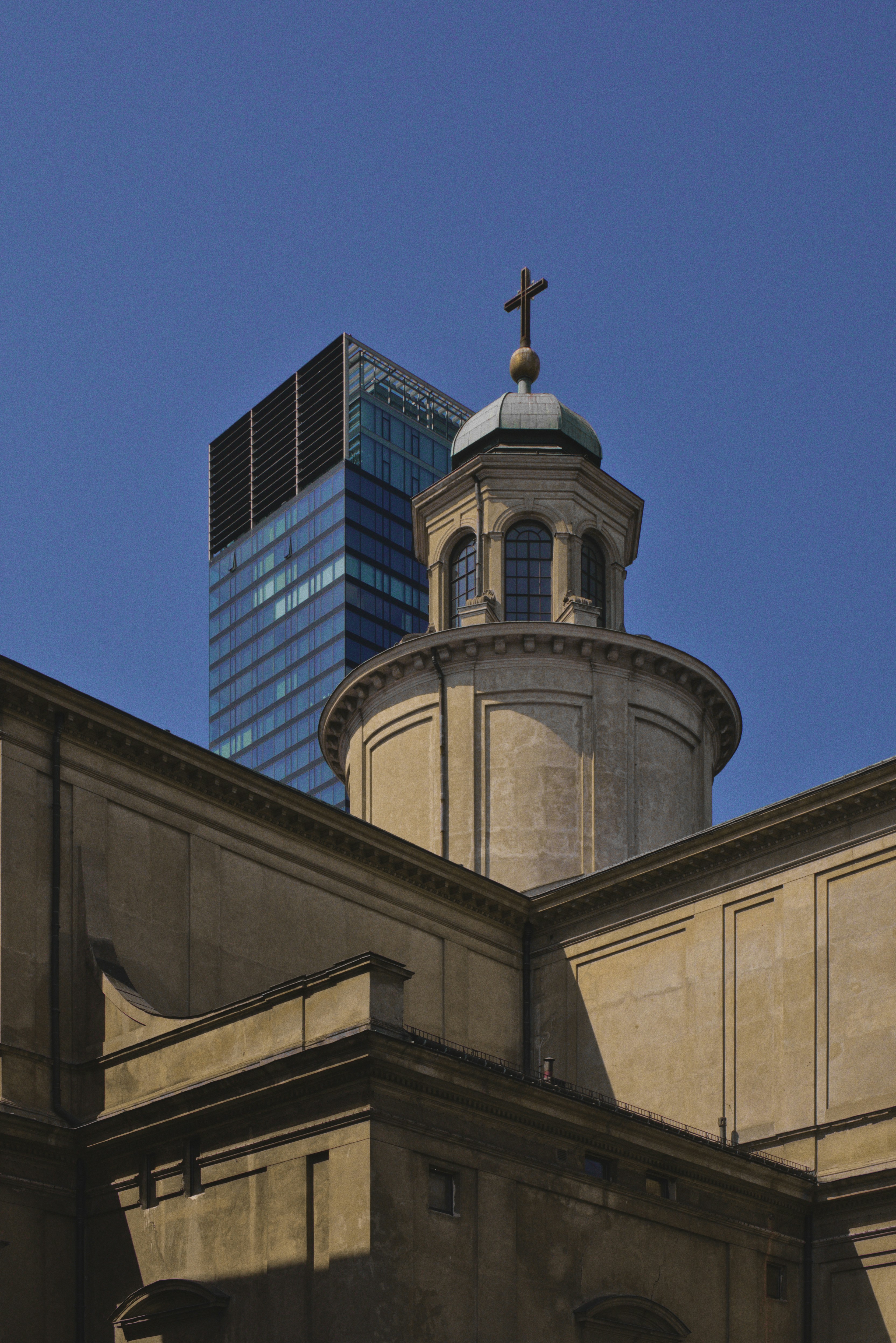 Historic church dome next to modern skyscraper