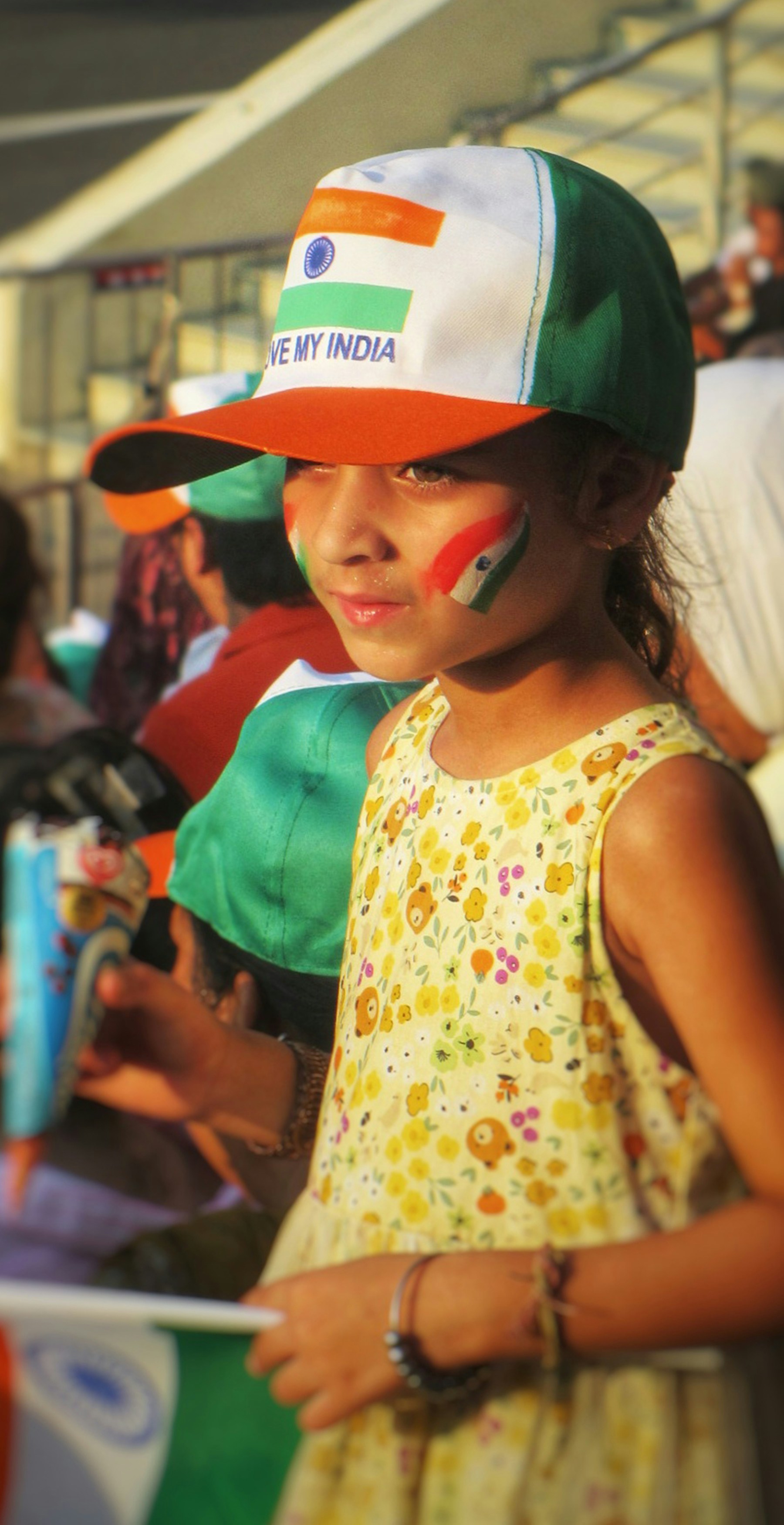 Young girl wears indian flag hat and face paint.