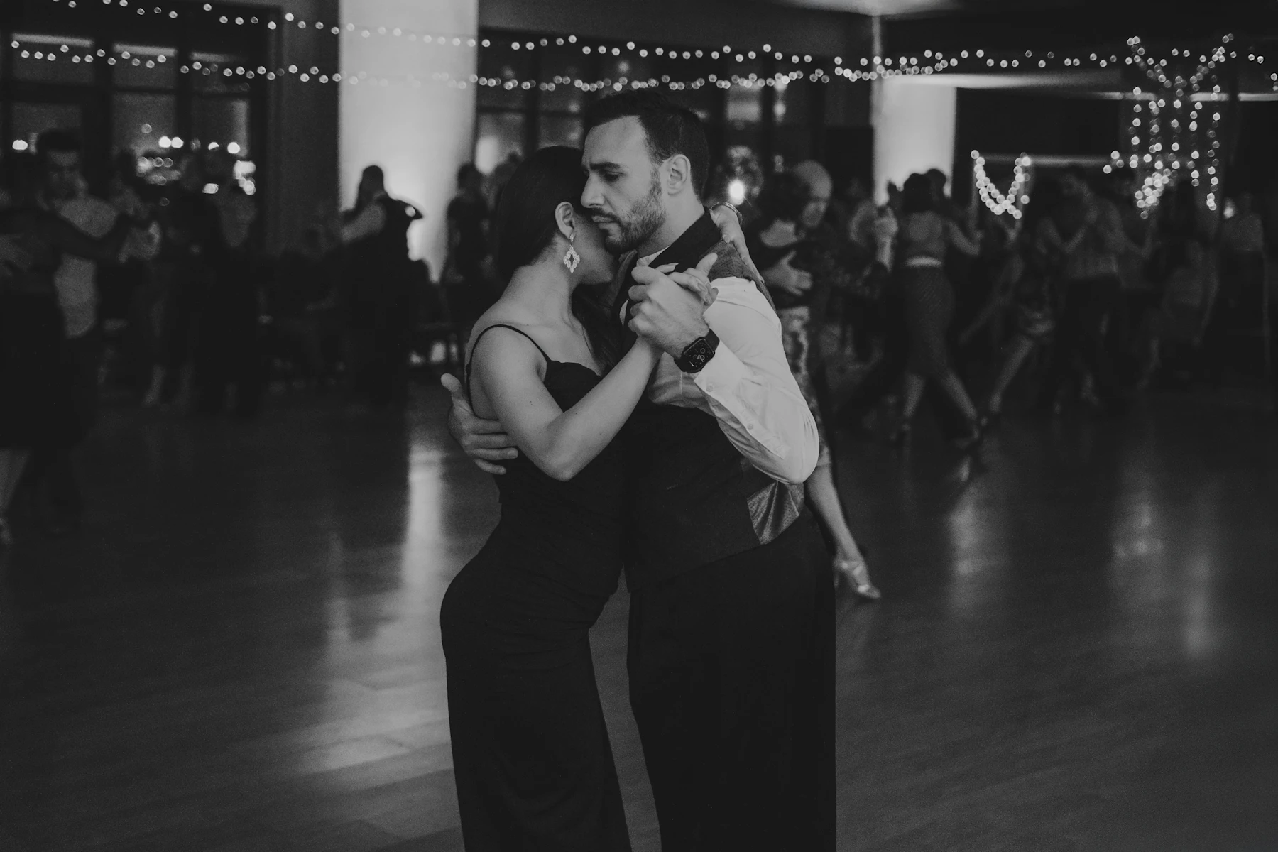 Couple dancing closely on a dimly lit social dance floor