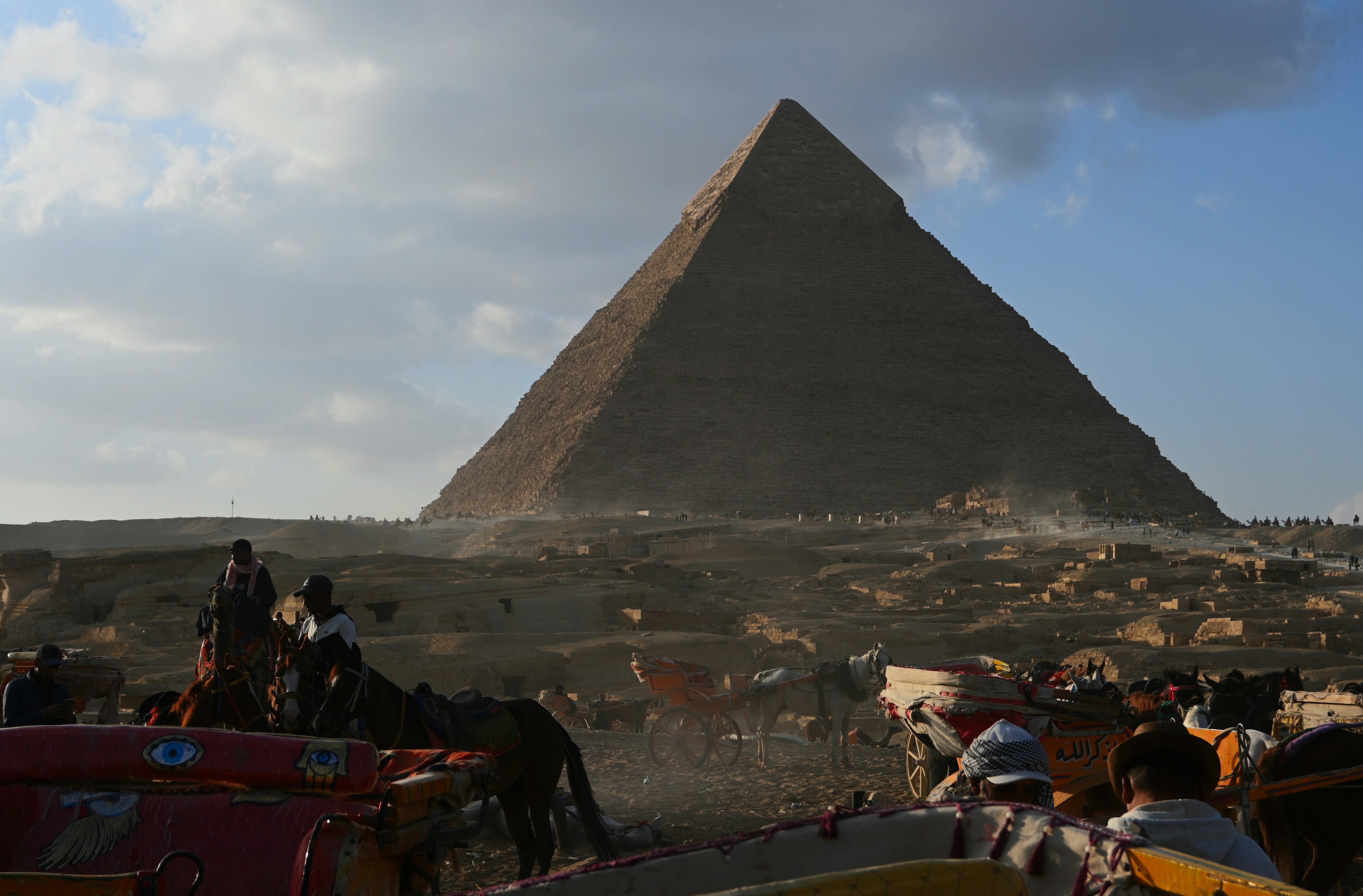 The great pyramid of giza with people and horses. - Giza