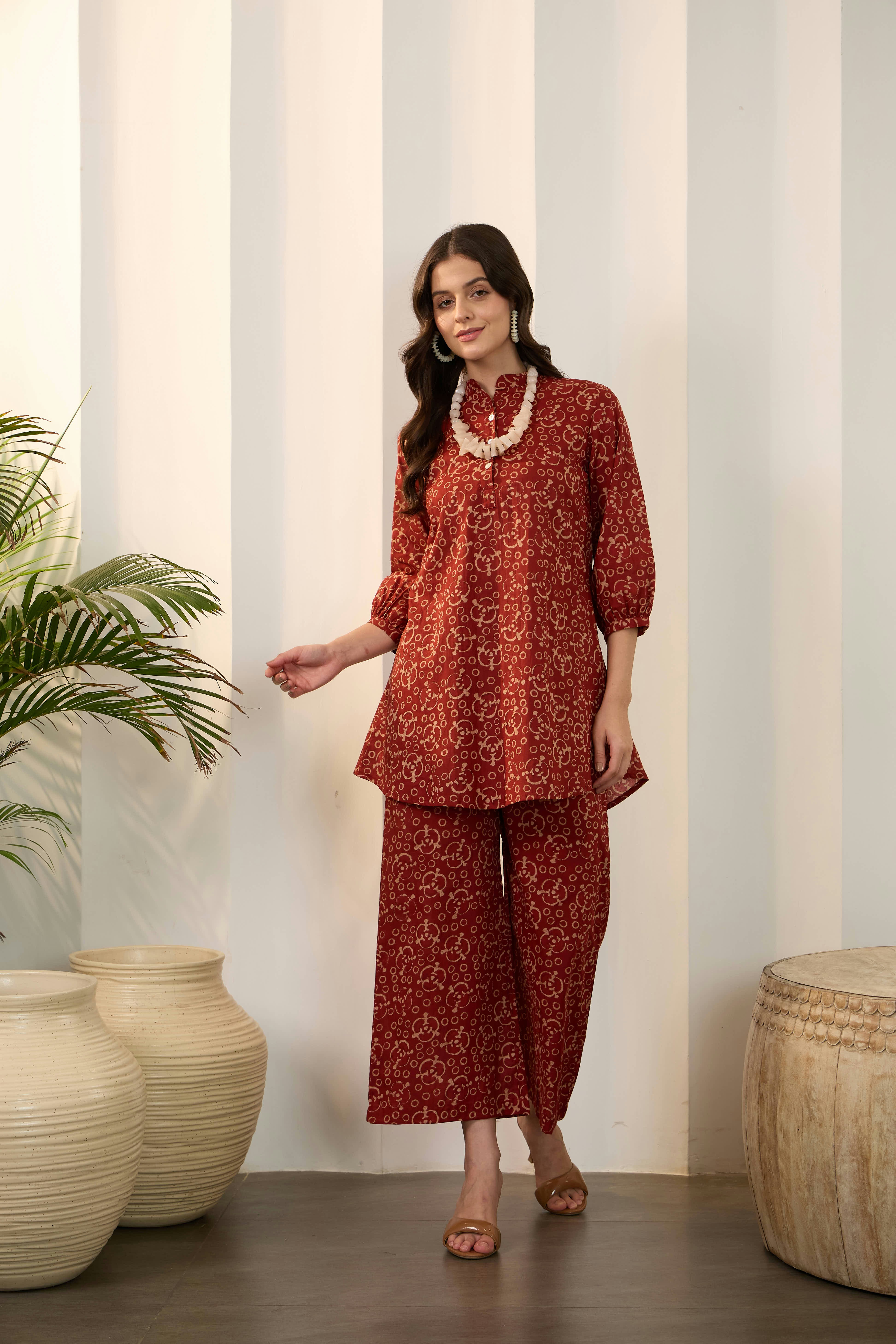 Woman in patterned outfit with statement necklace