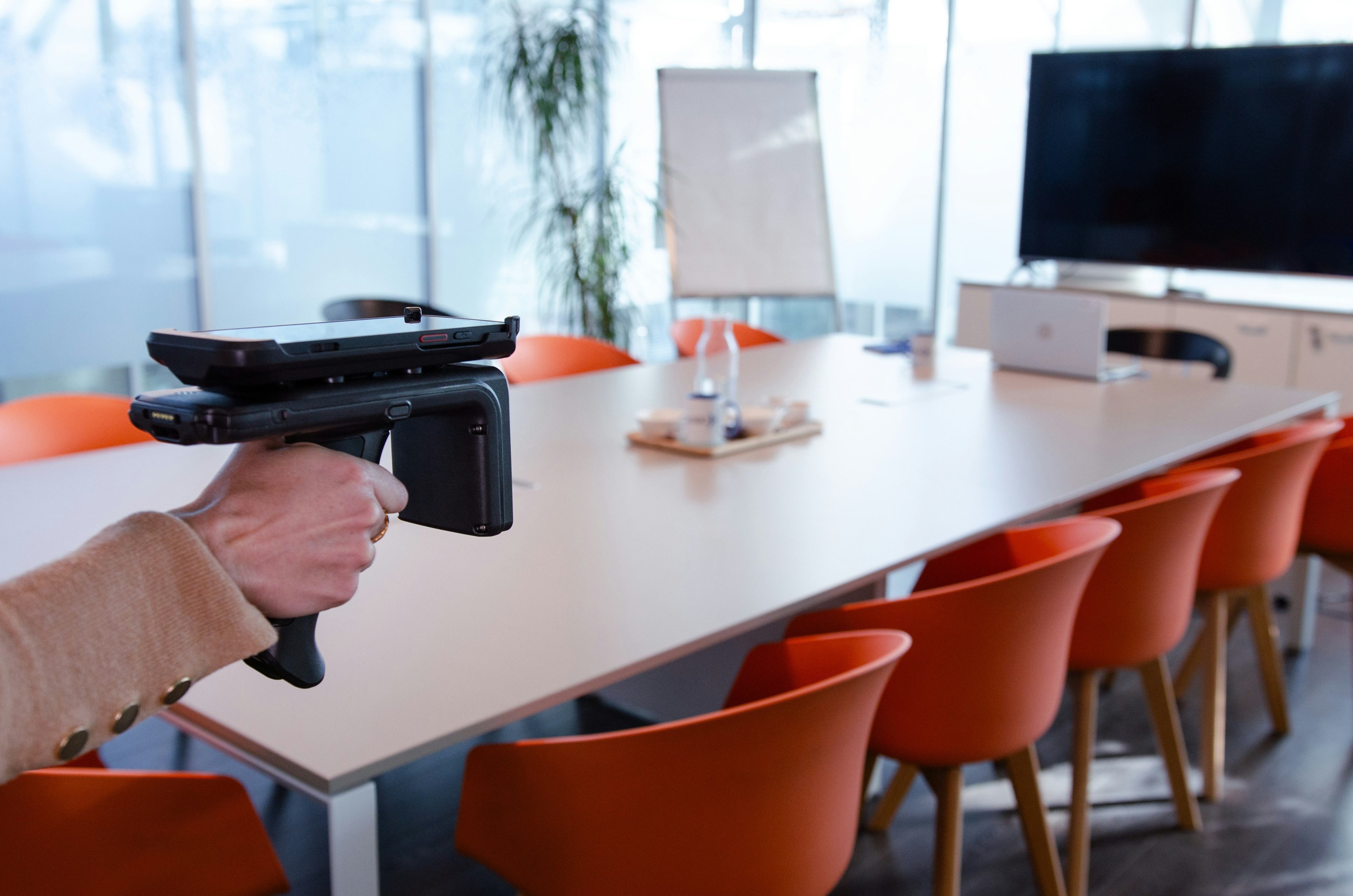 Hand holding a portable scanner in conference room
