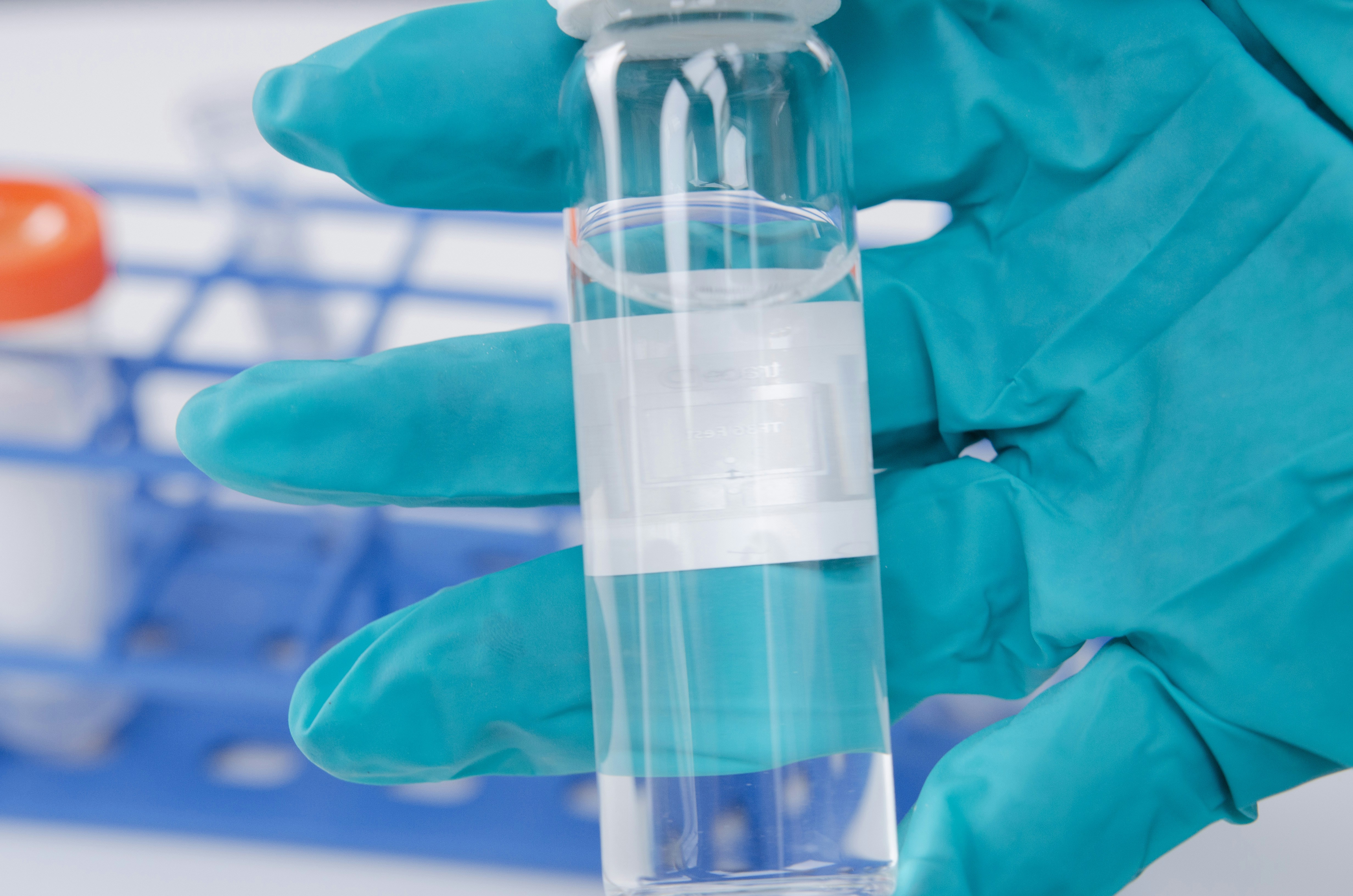 Gloved hand holding a clear laboratory vial containing liquid, representing Abbott Laboratories’ healthcare and diagnostics business following its quarterly earnings report.