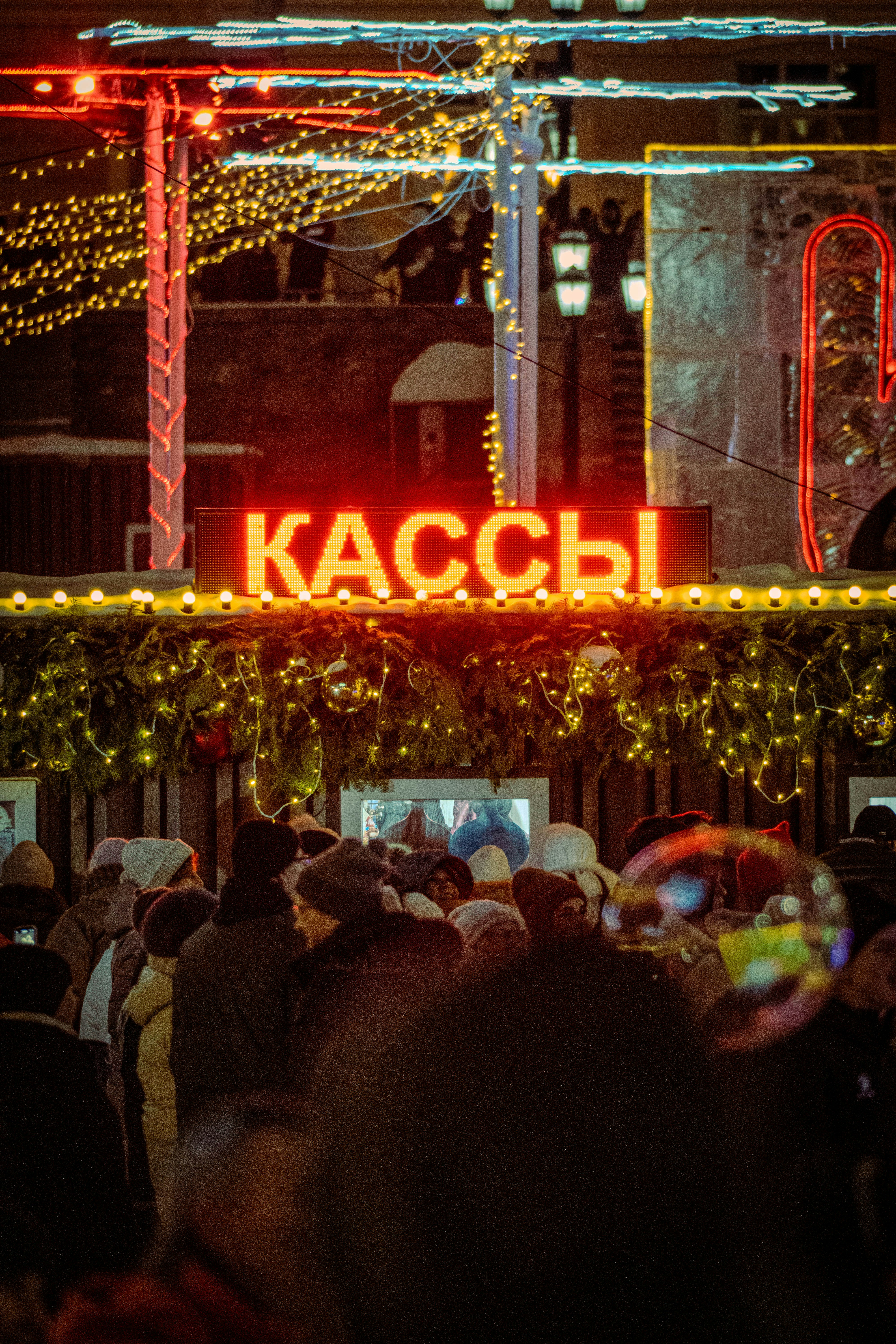 Gente haciendo cola en una taquilla iluminada por la noche