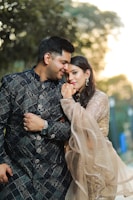 A couple embracing outdoors during golden hour.