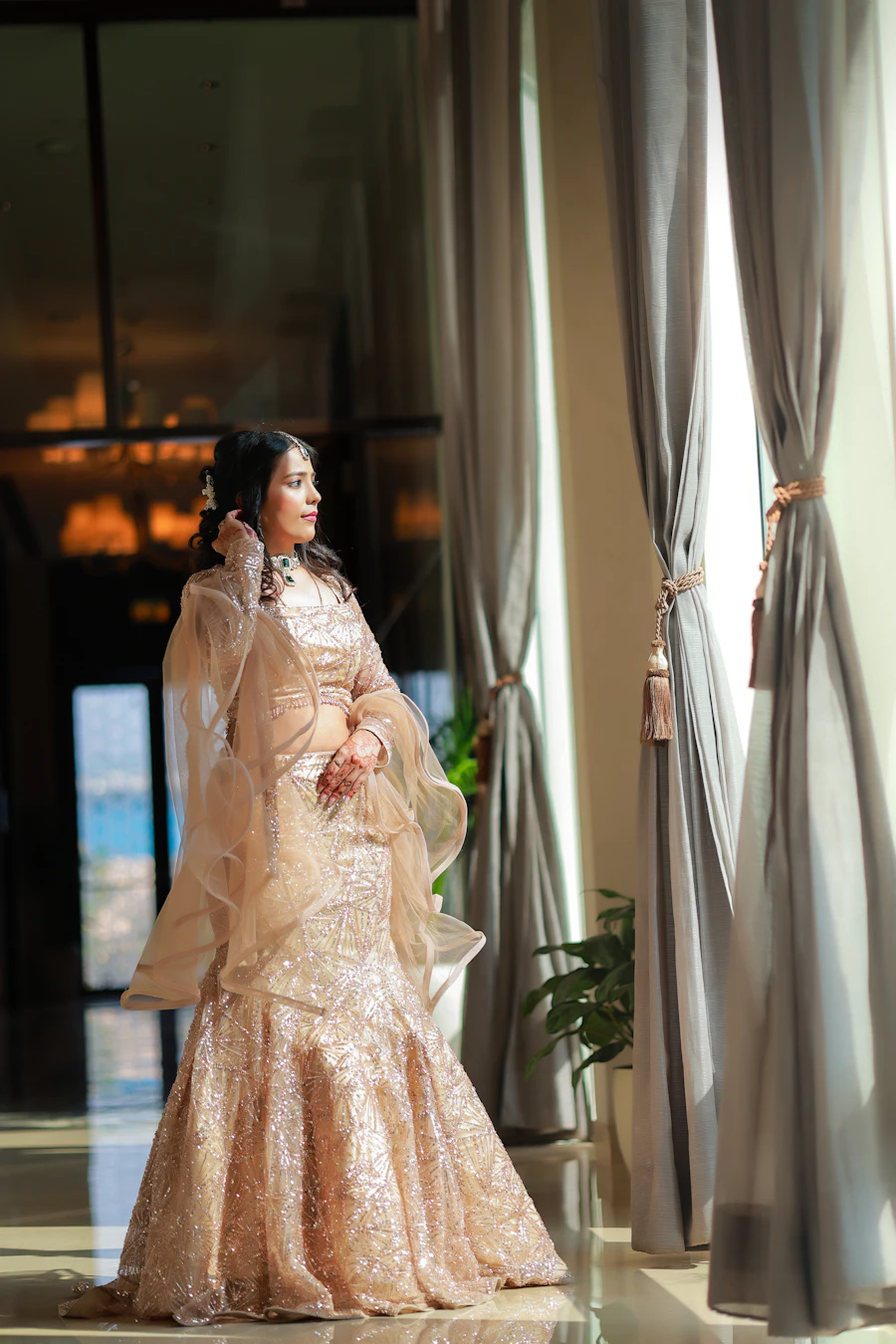 Champagne embroidered lehenga by a window