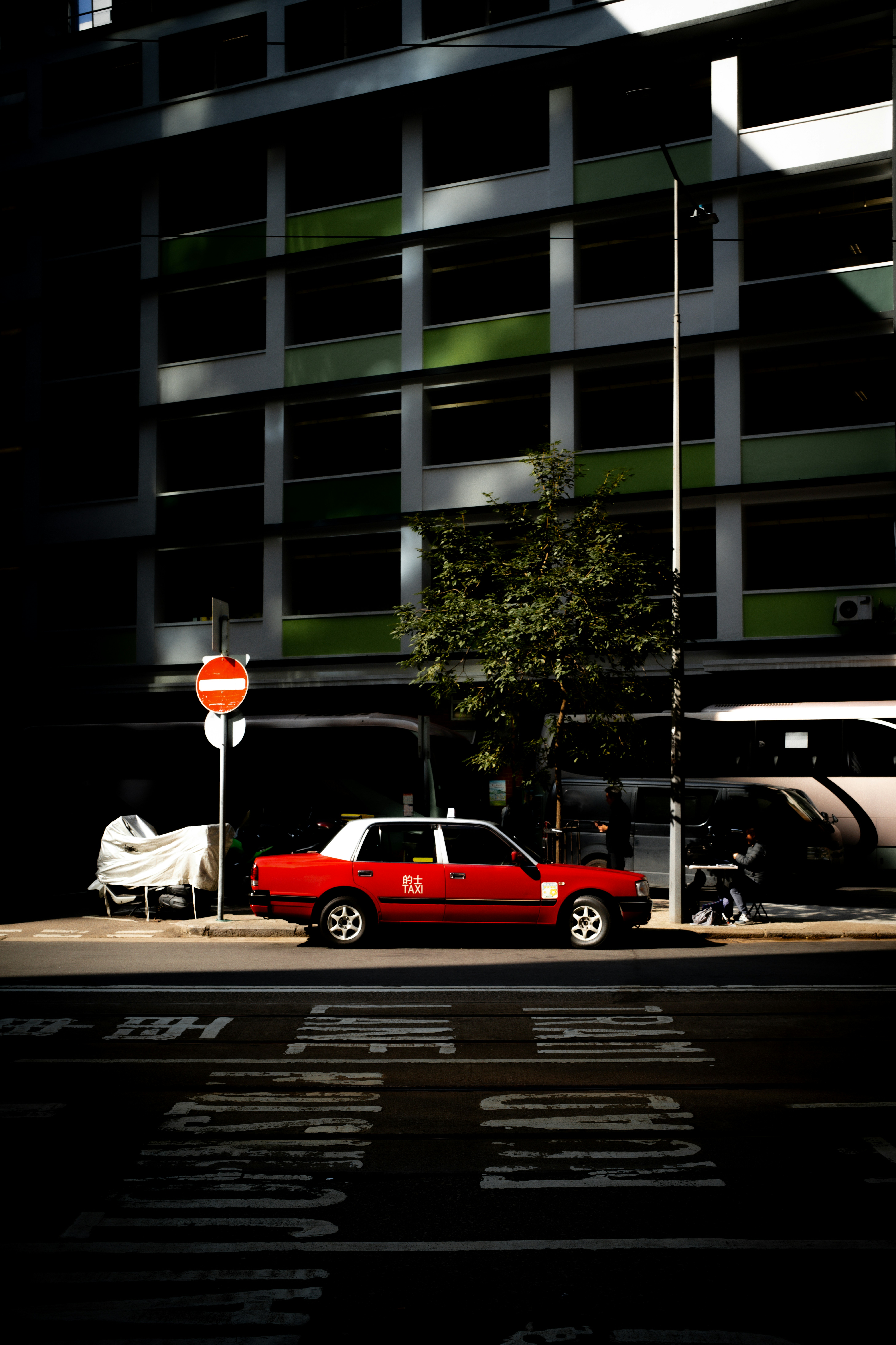Red taxi parked on a city street.