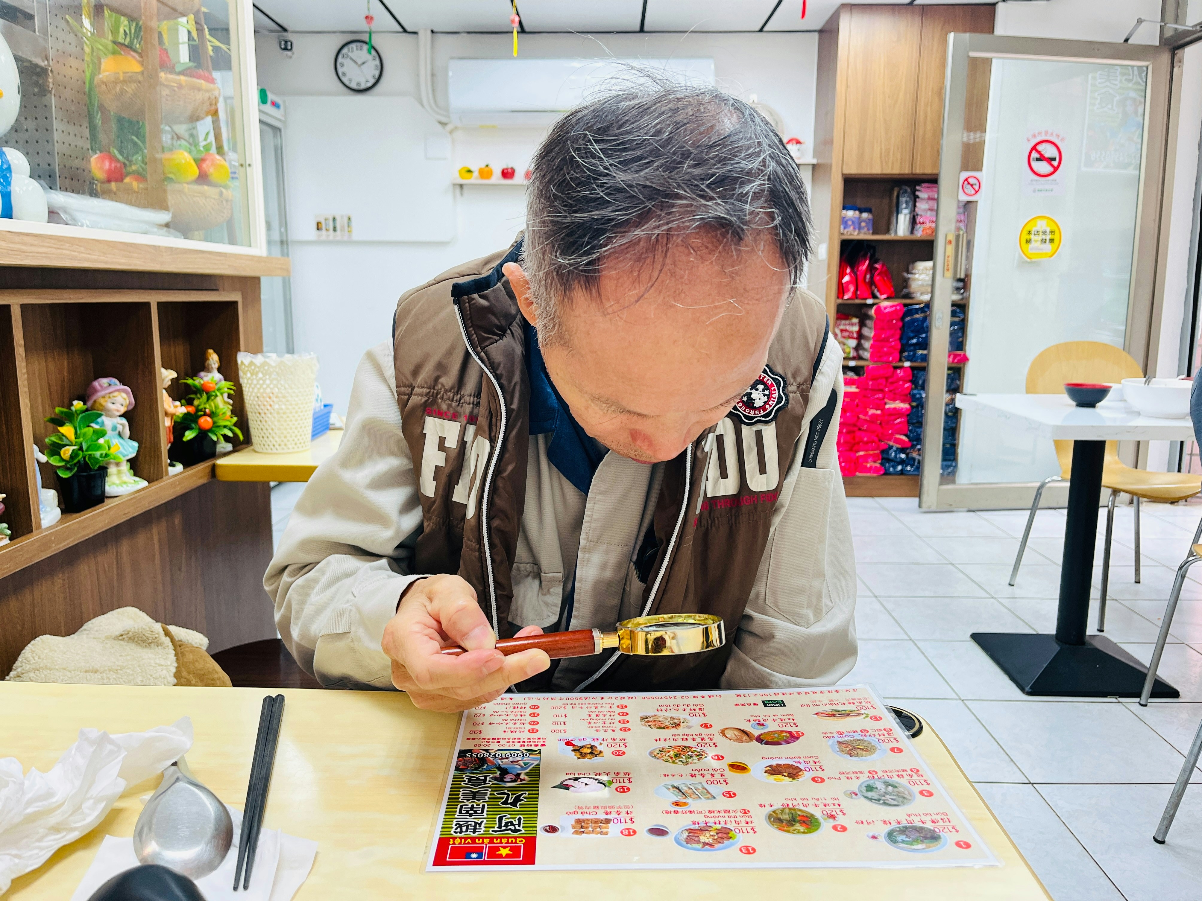 Mann, der mit einer Lupe eine Speisekarte betrachtet