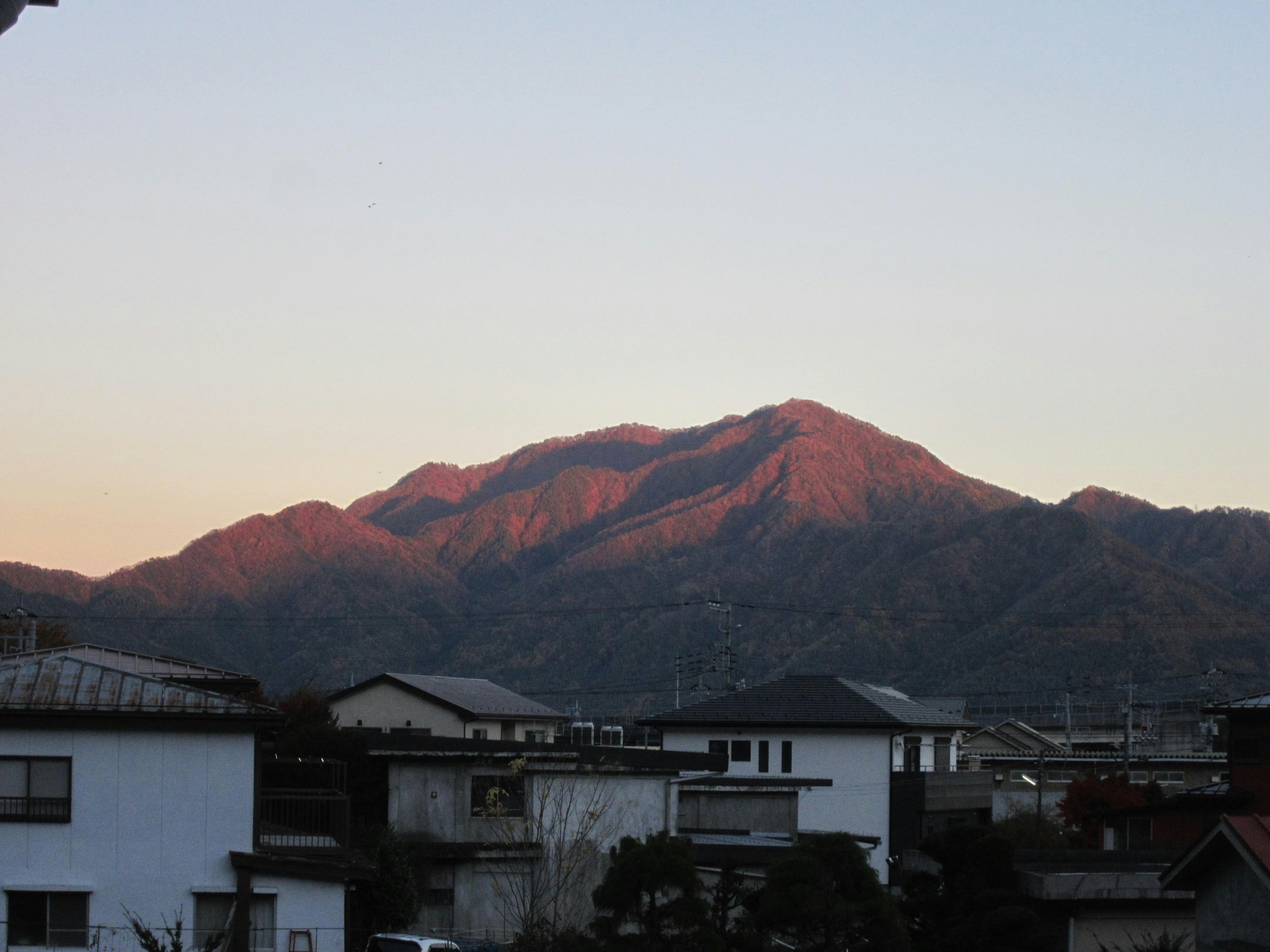 Mountain illuminated by sunset over a town