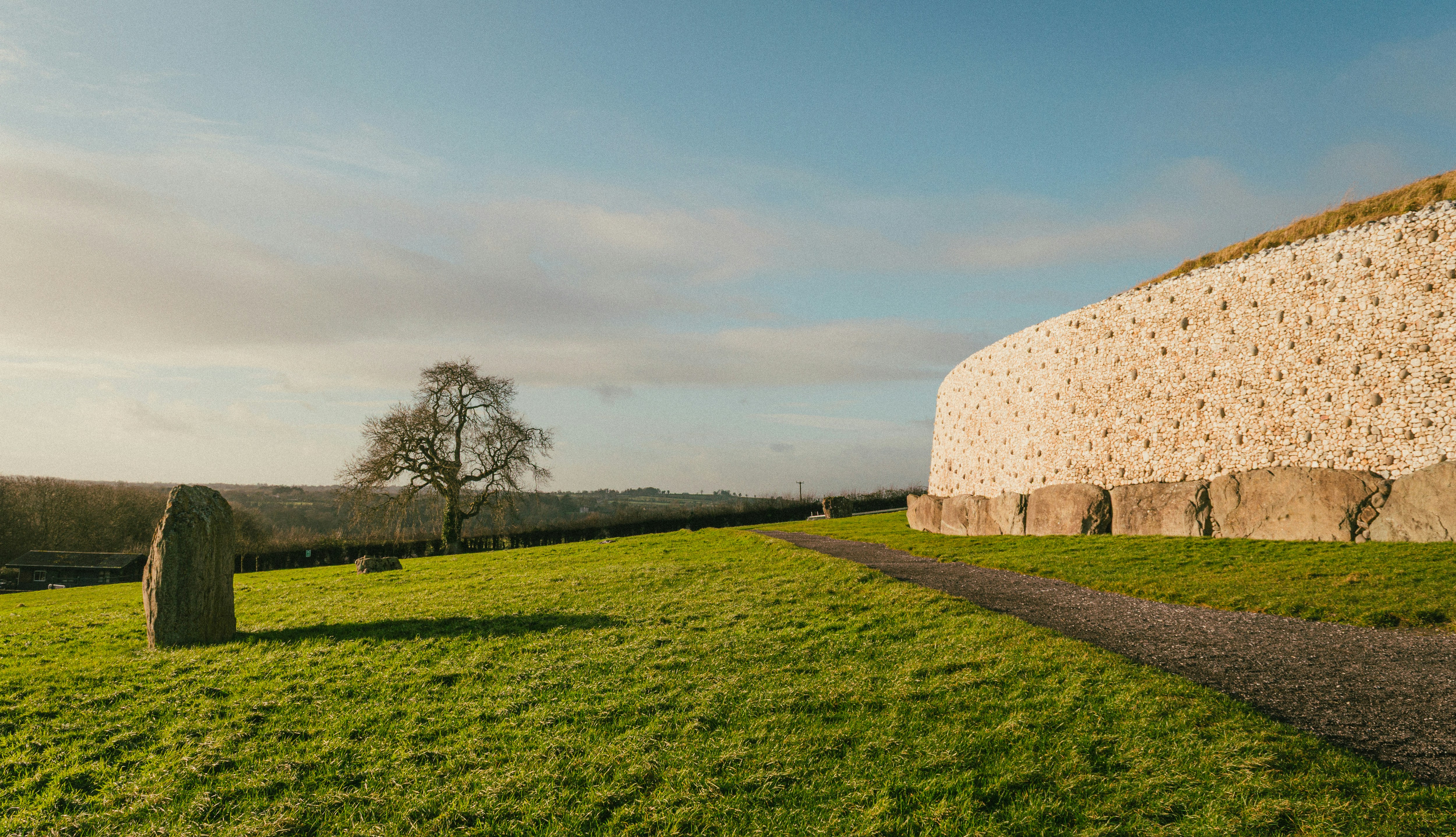 Ancient stone monument on a grassy field under sky