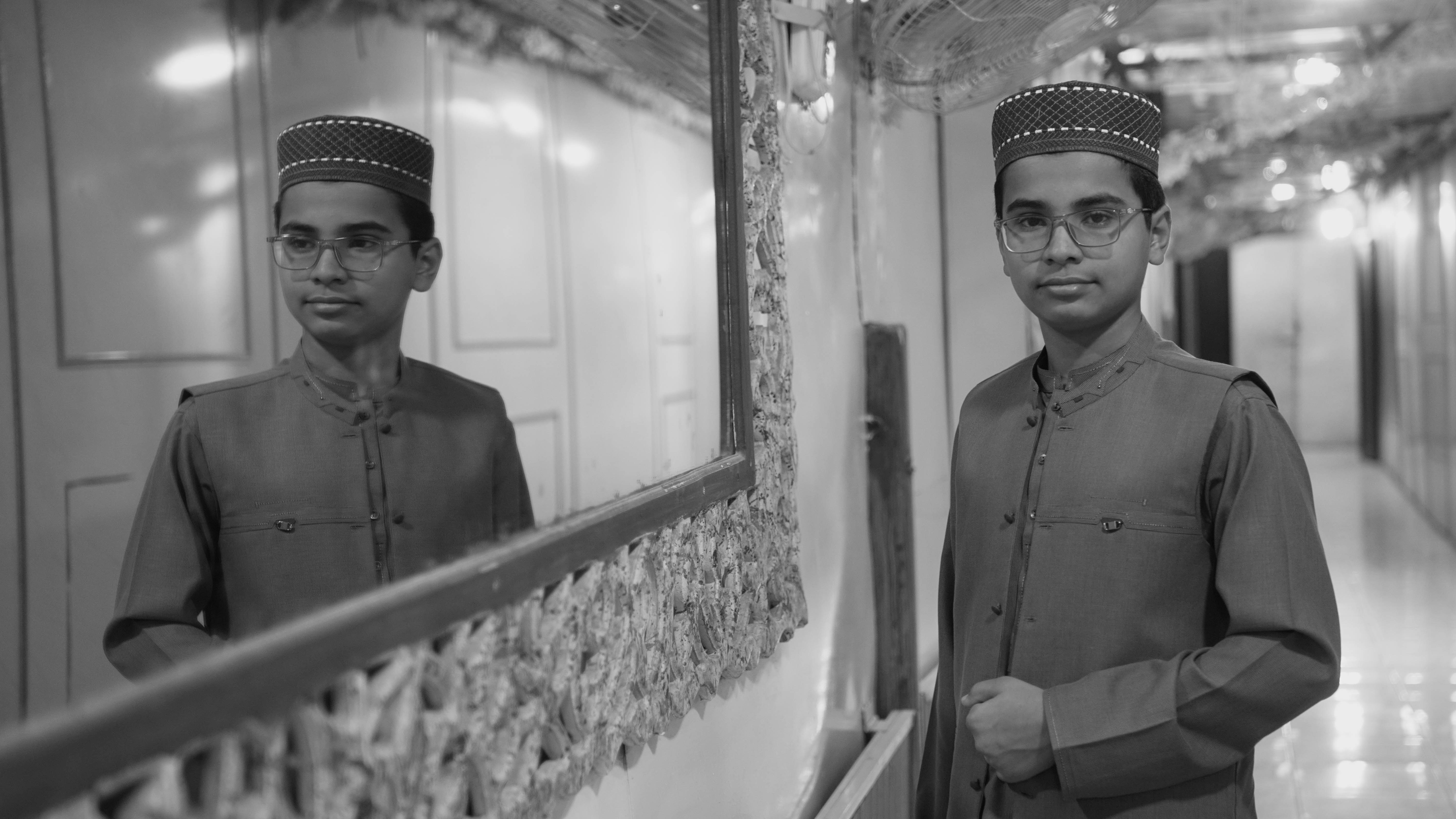 Man in traditional attire standing in front of a mirror