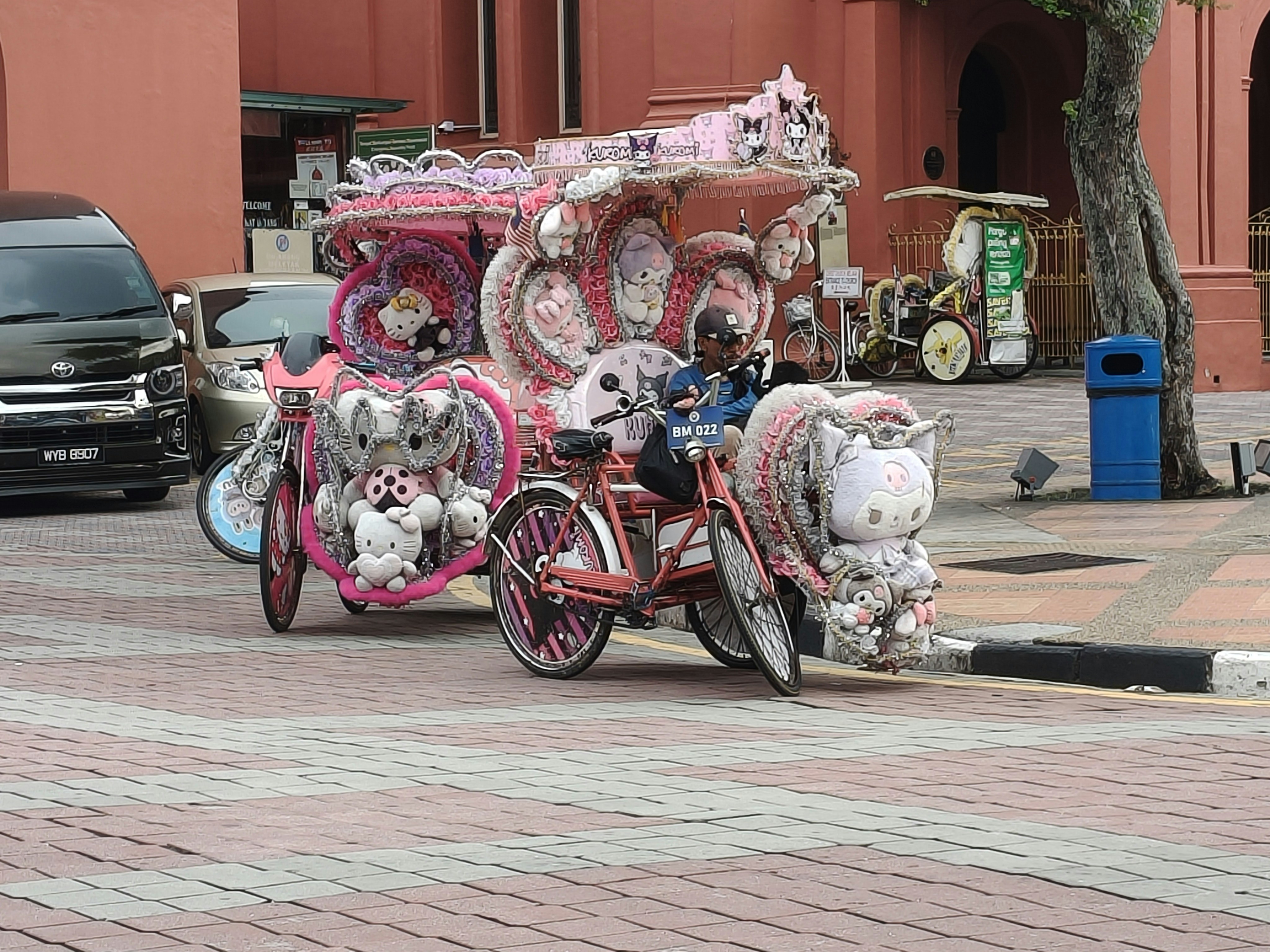 Pink hello kitty themed trishaw decorated with plush toys
