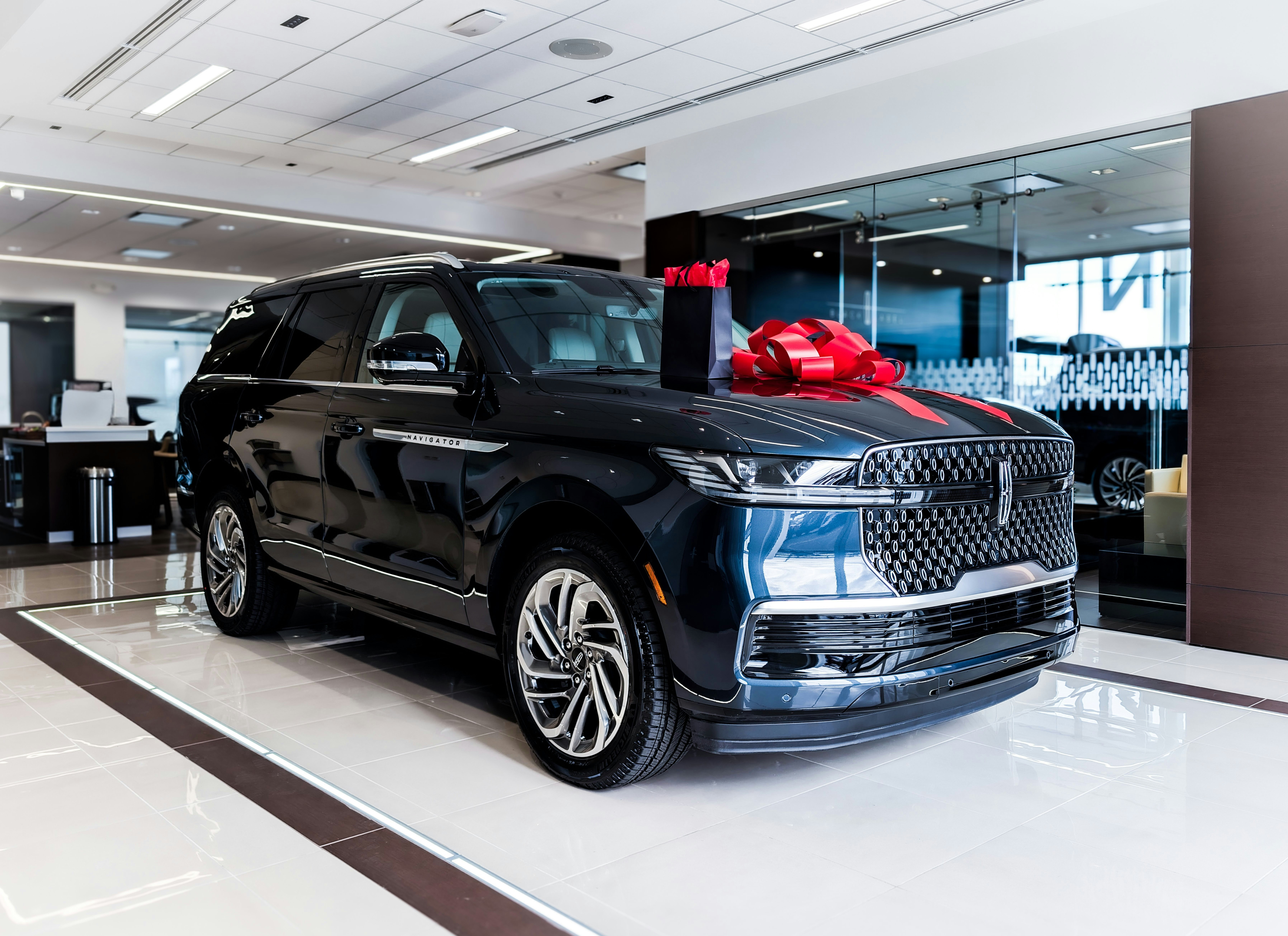 Dark blue luxury suv with red bow on hood