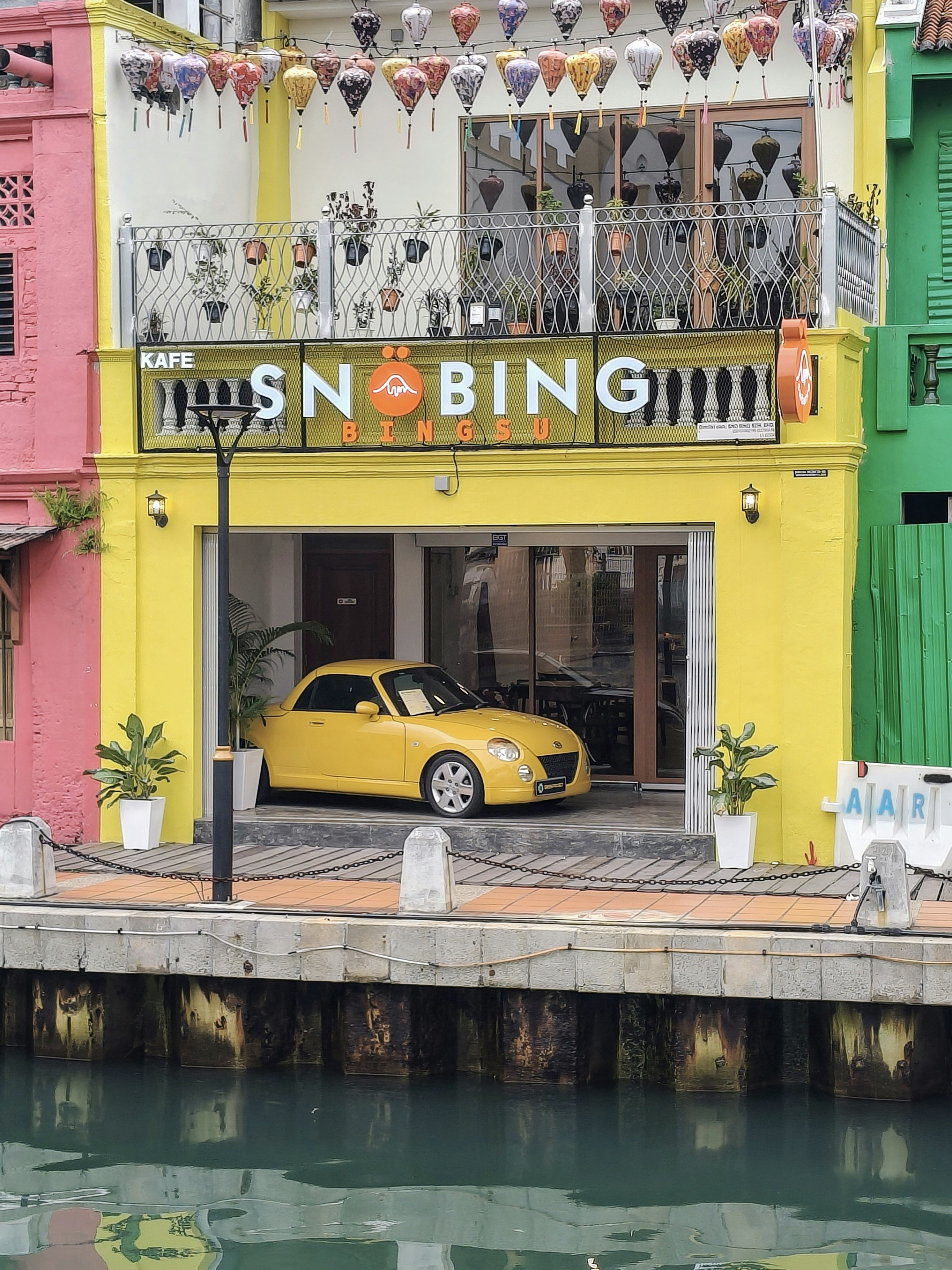 Yellow car parked outside a colorful building