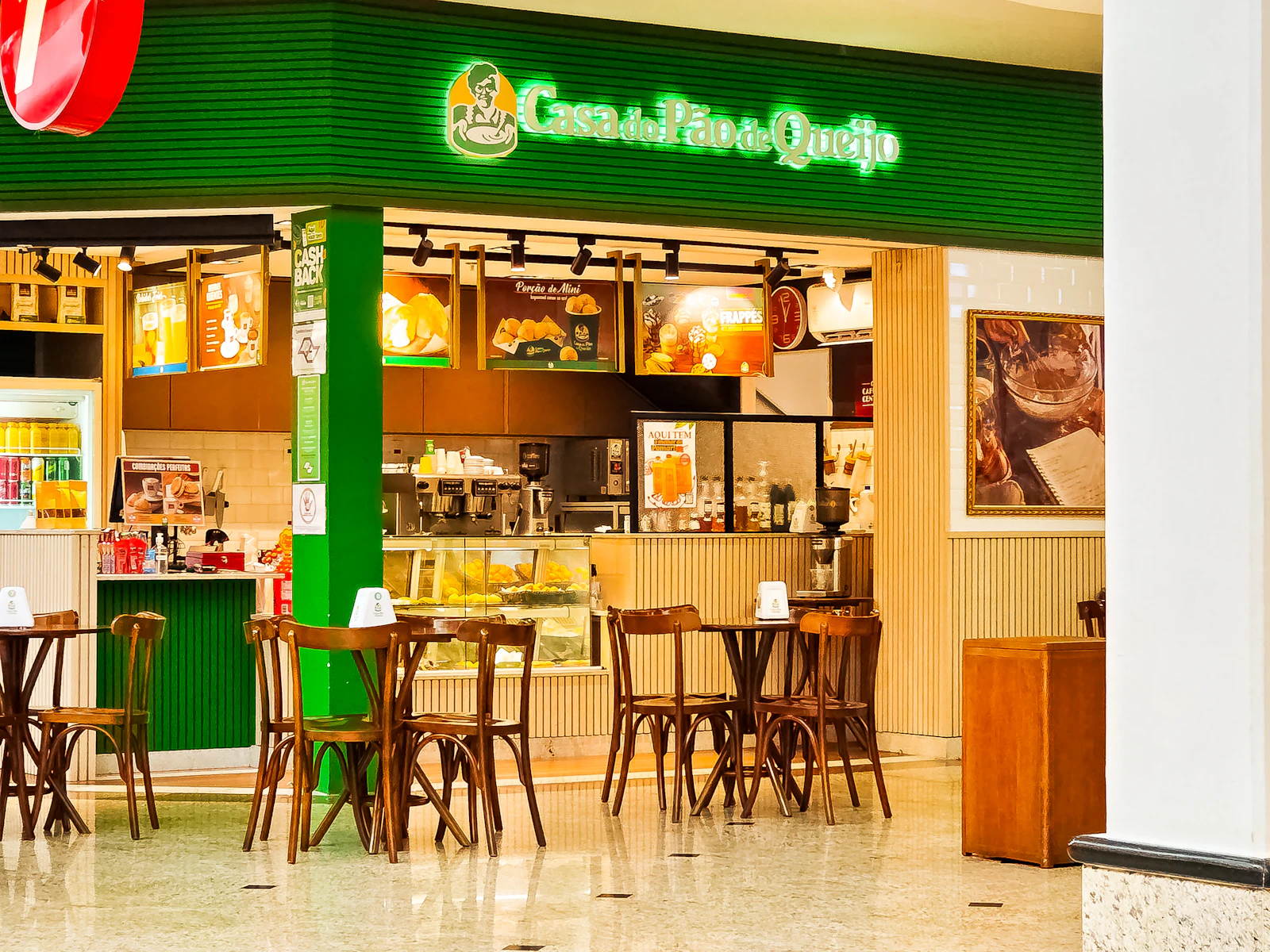 Green storefront cafe with tables and chairs outside