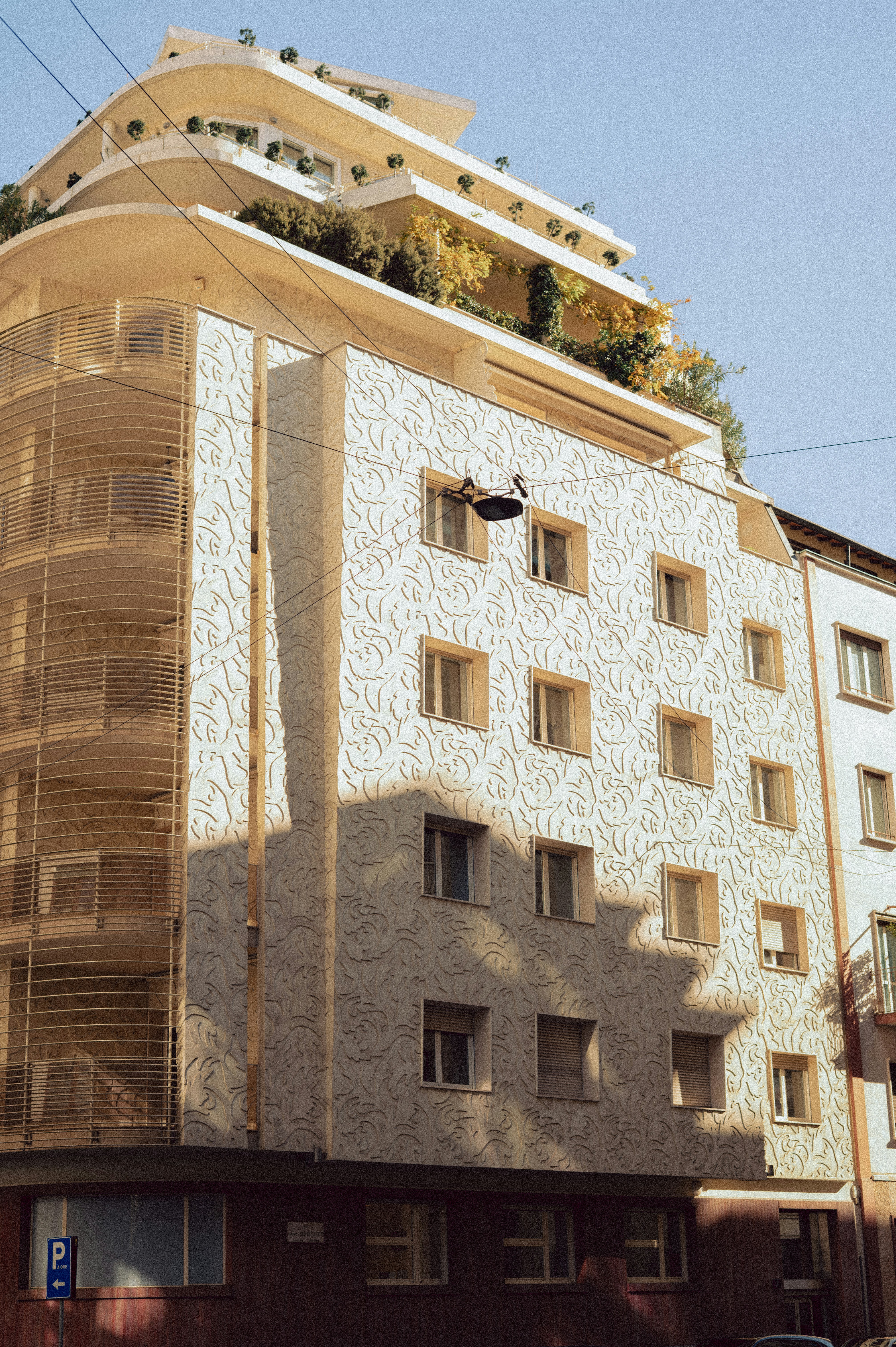 Modernes Gebäude mit einzigartiger strukturierter Fassade und grünem Dach.