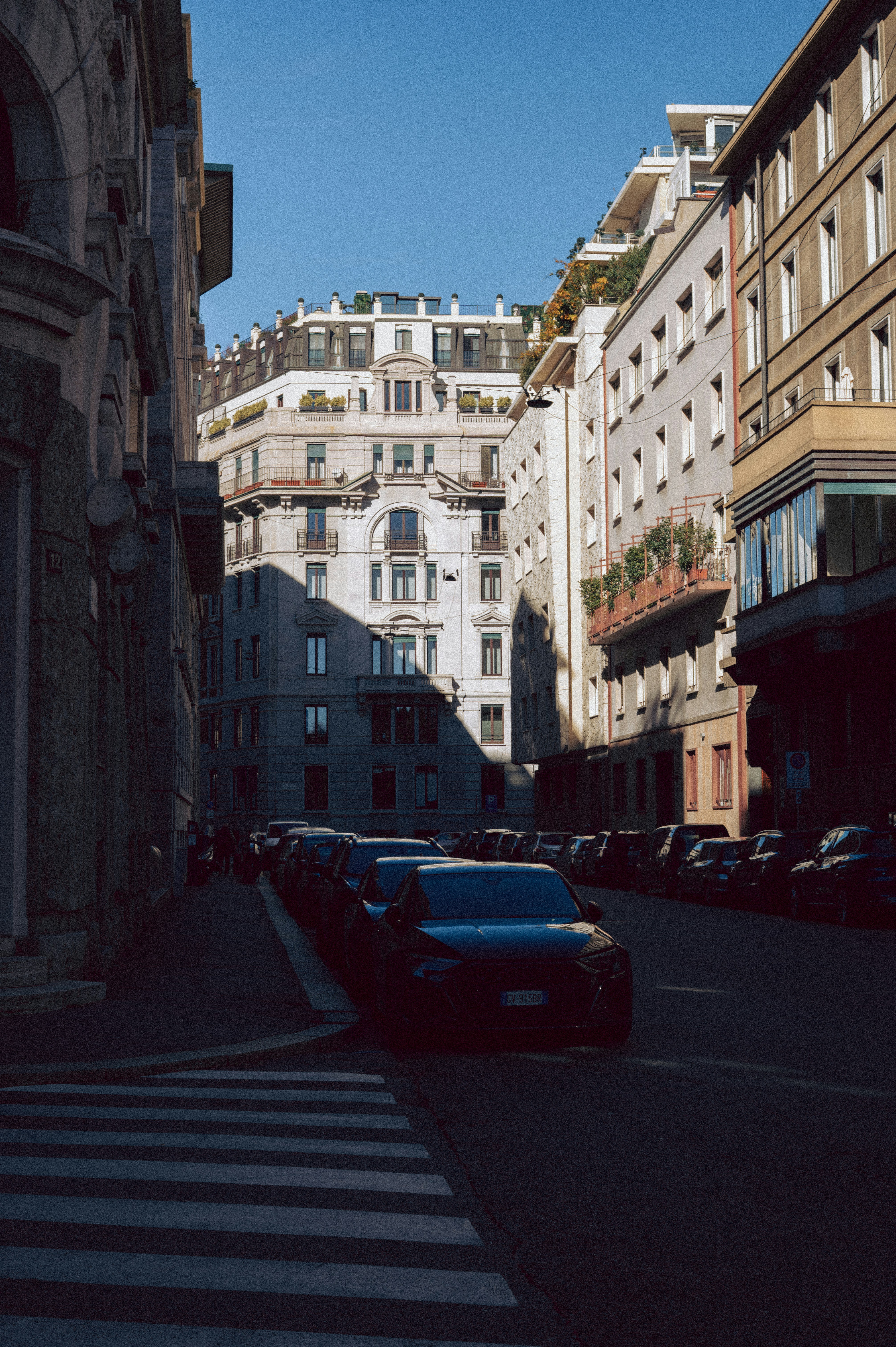 Autos parkten entlang einer sonnenverwöhnten Stadtstraße.