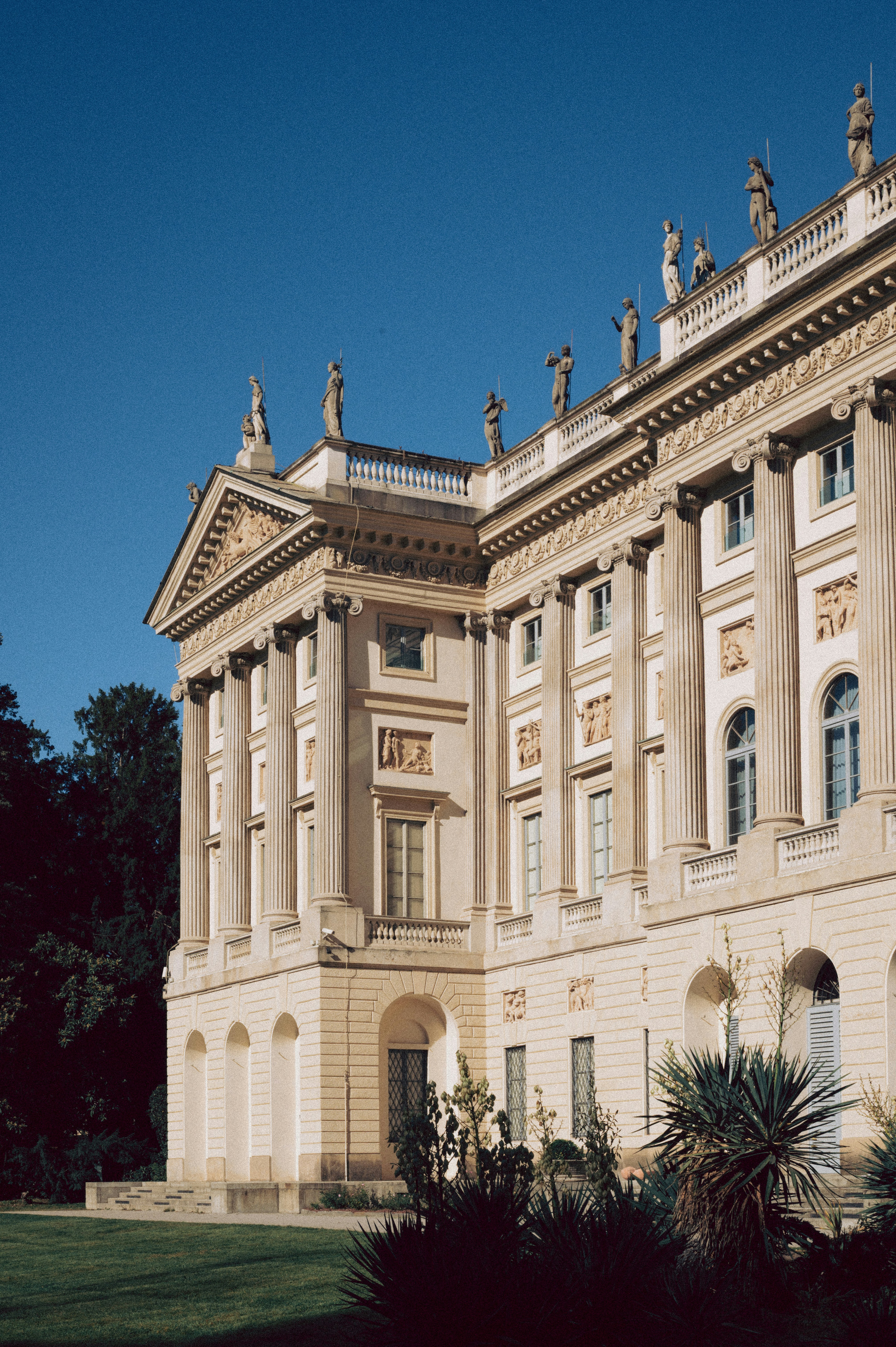 Großes klassizistisches Gebäude mit kunstvollen Details und Statuen.