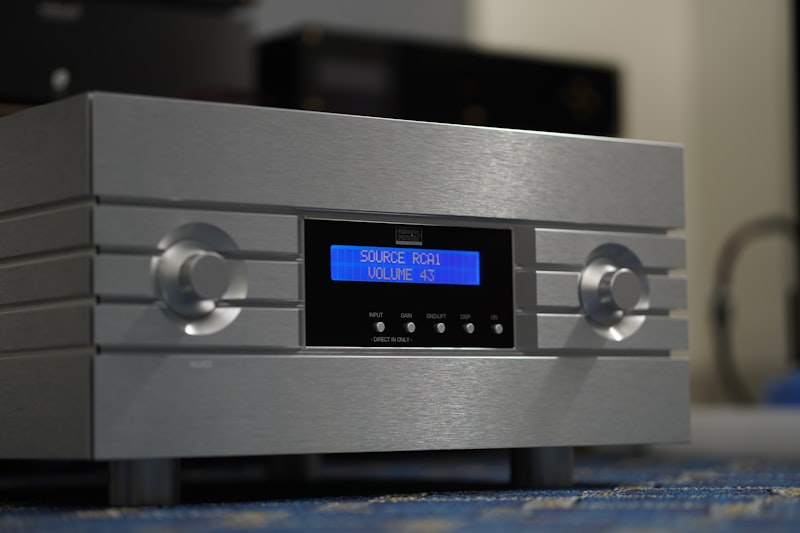 Silver audio amplifier with blue screen display.