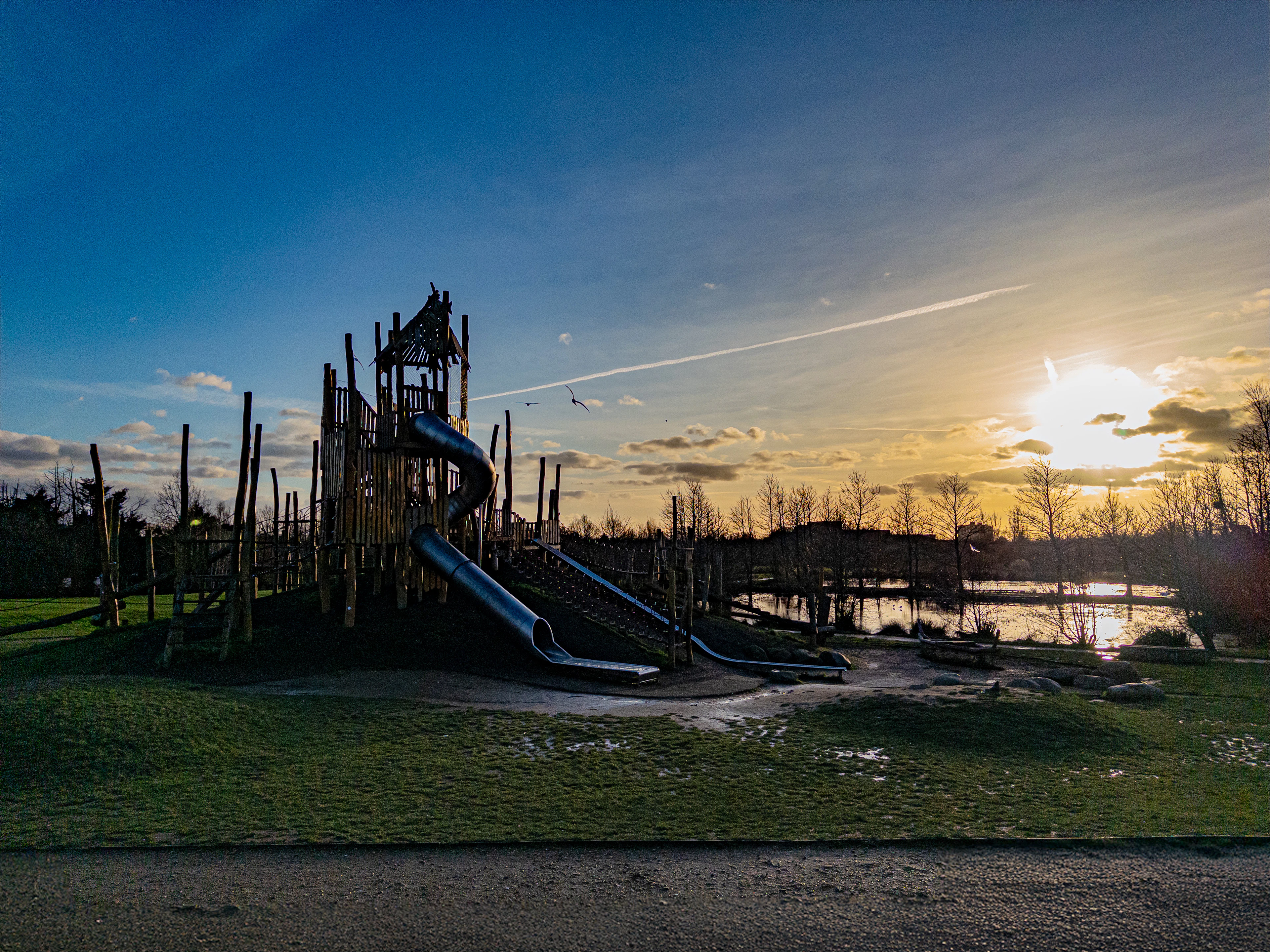 Playground beside a lake at sunset
