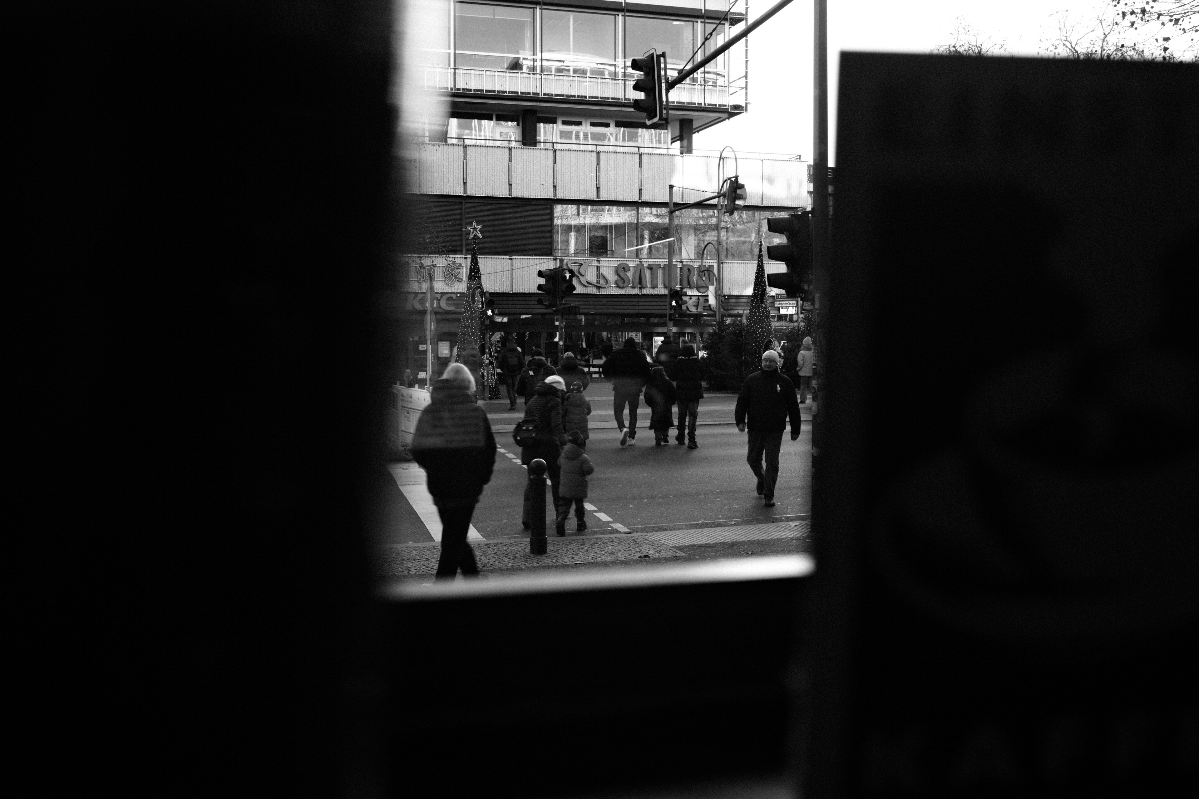 People walking on a city street with buildings.