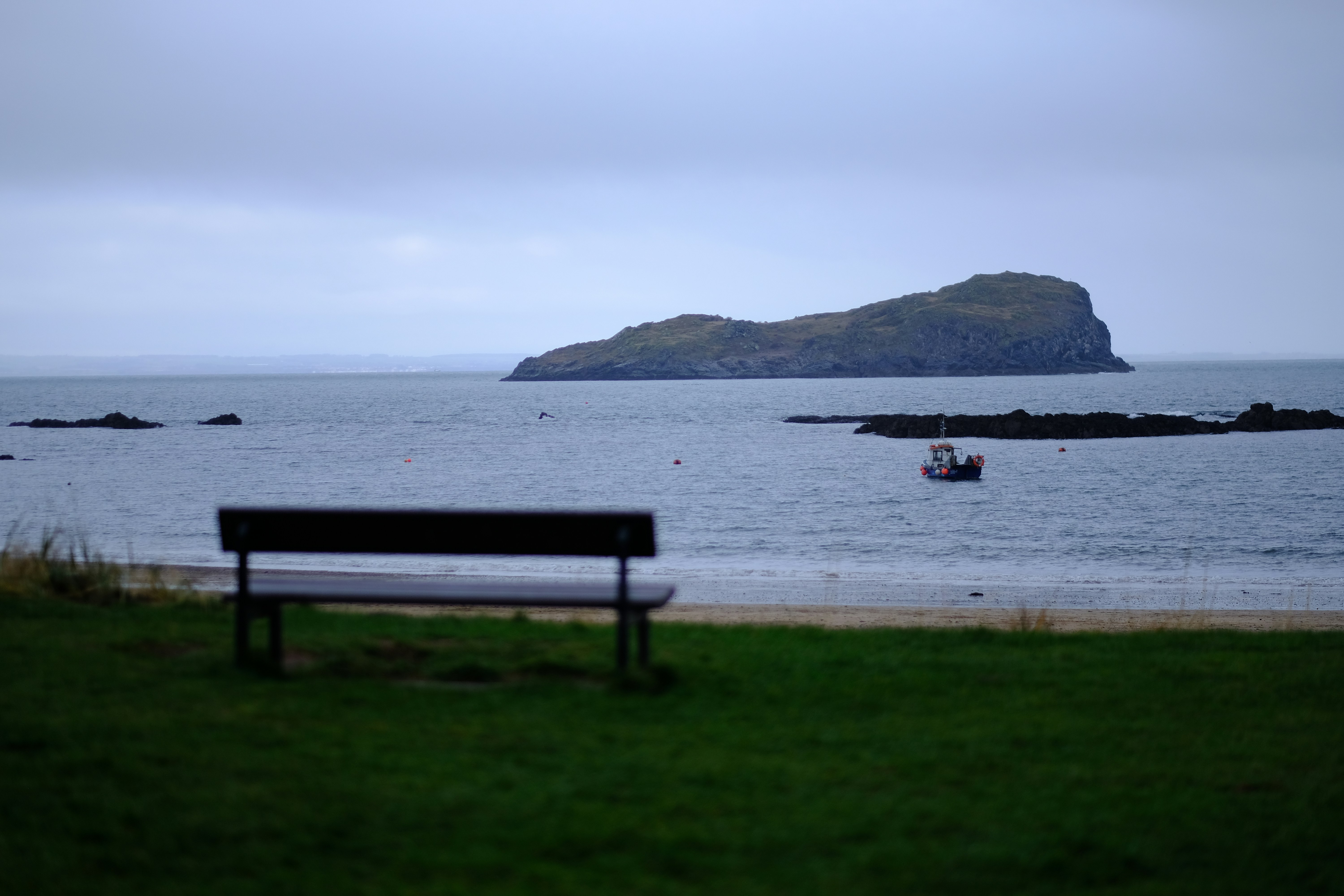 Bench overlooking island and calm sea