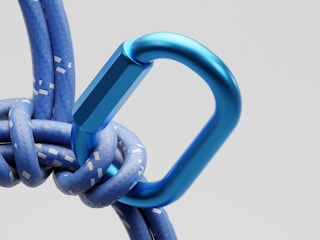 Blue carabiner attached to a rope.