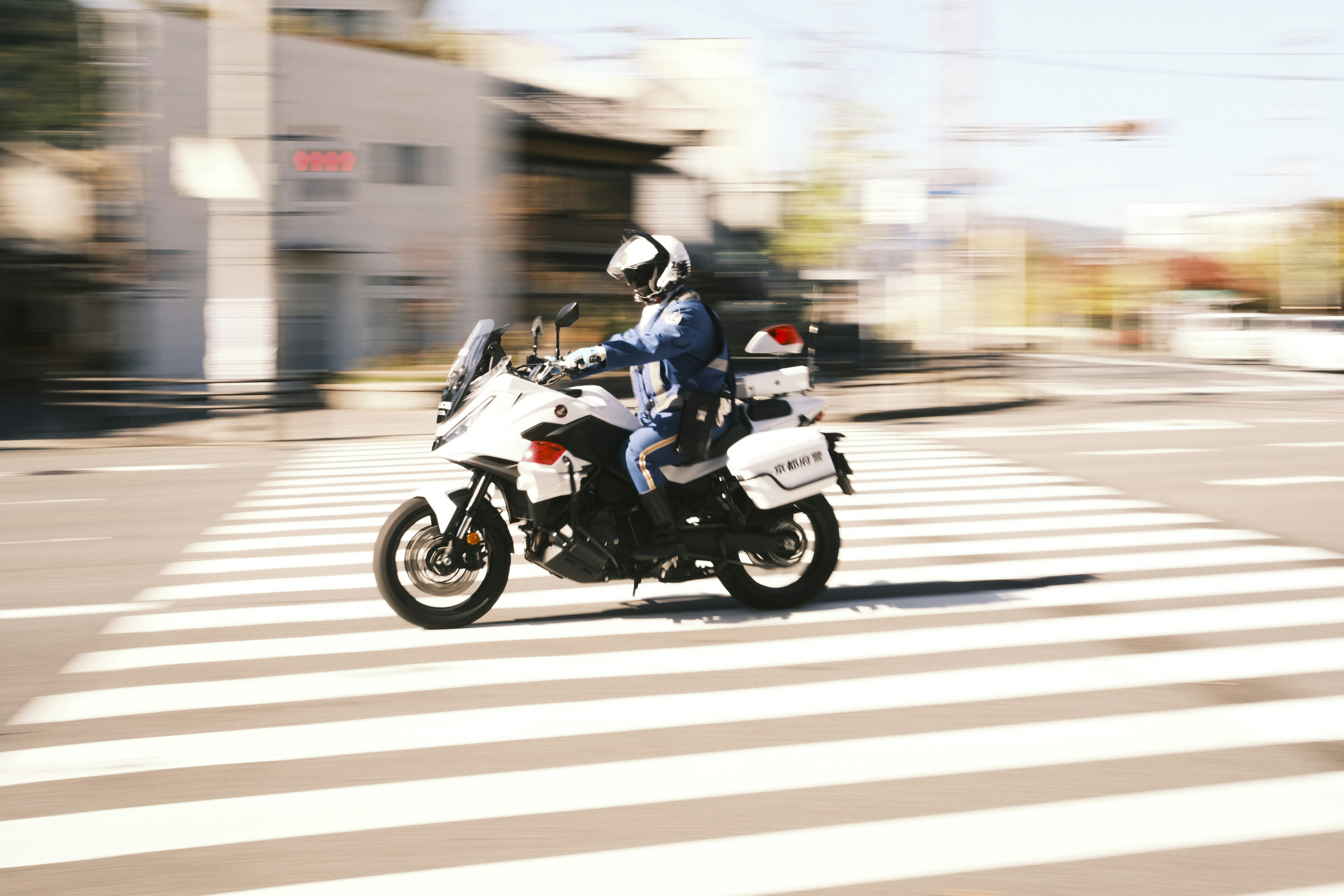 Police officer riding motorcycle across crosswalk