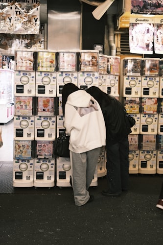 Rows of colorful gachapon capsule toy machines in a Tokyo arcade