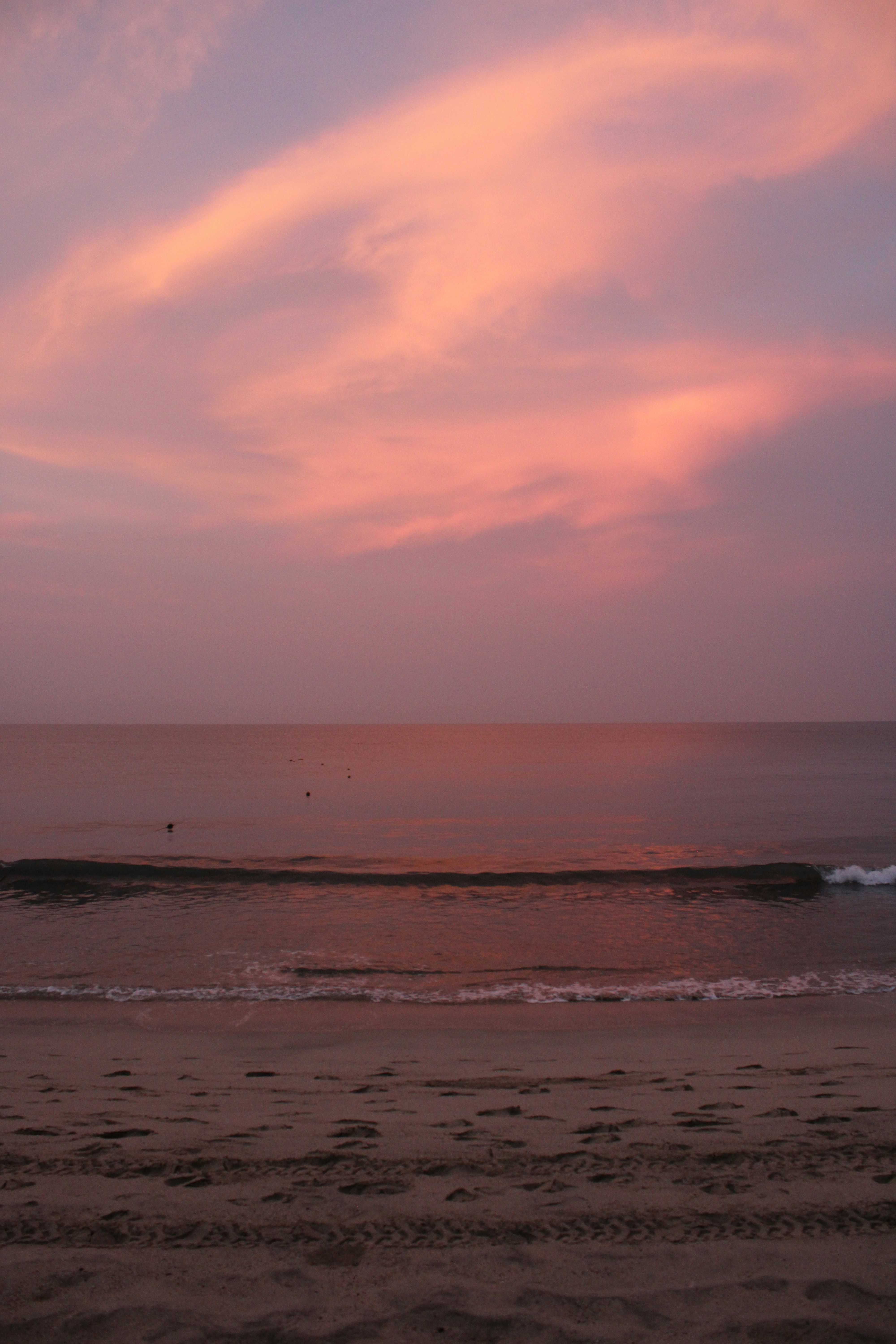 Nuages roses sur un océan calme au coucher du soleil