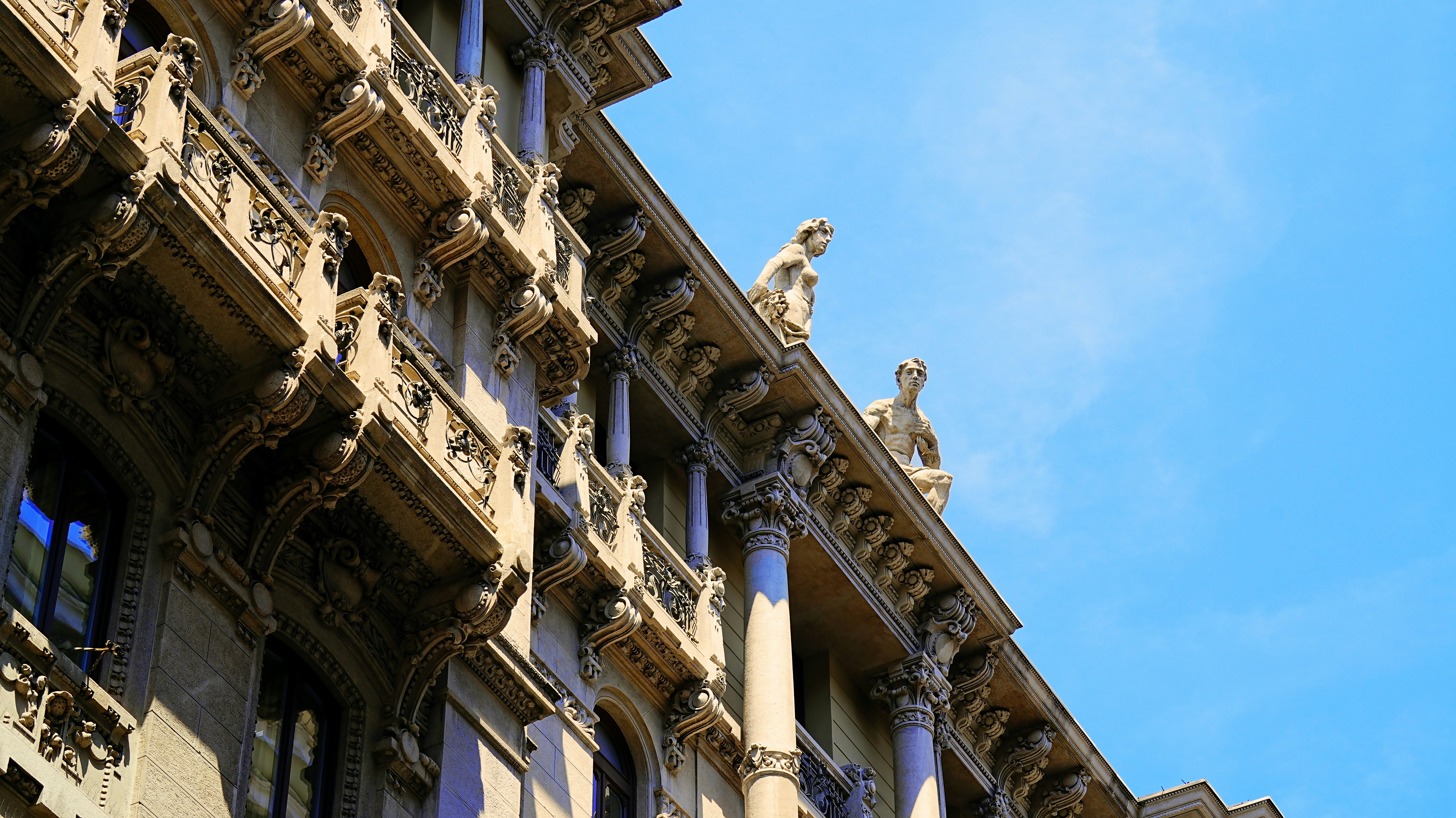 Ornate building facade with gargoyles against blue sky