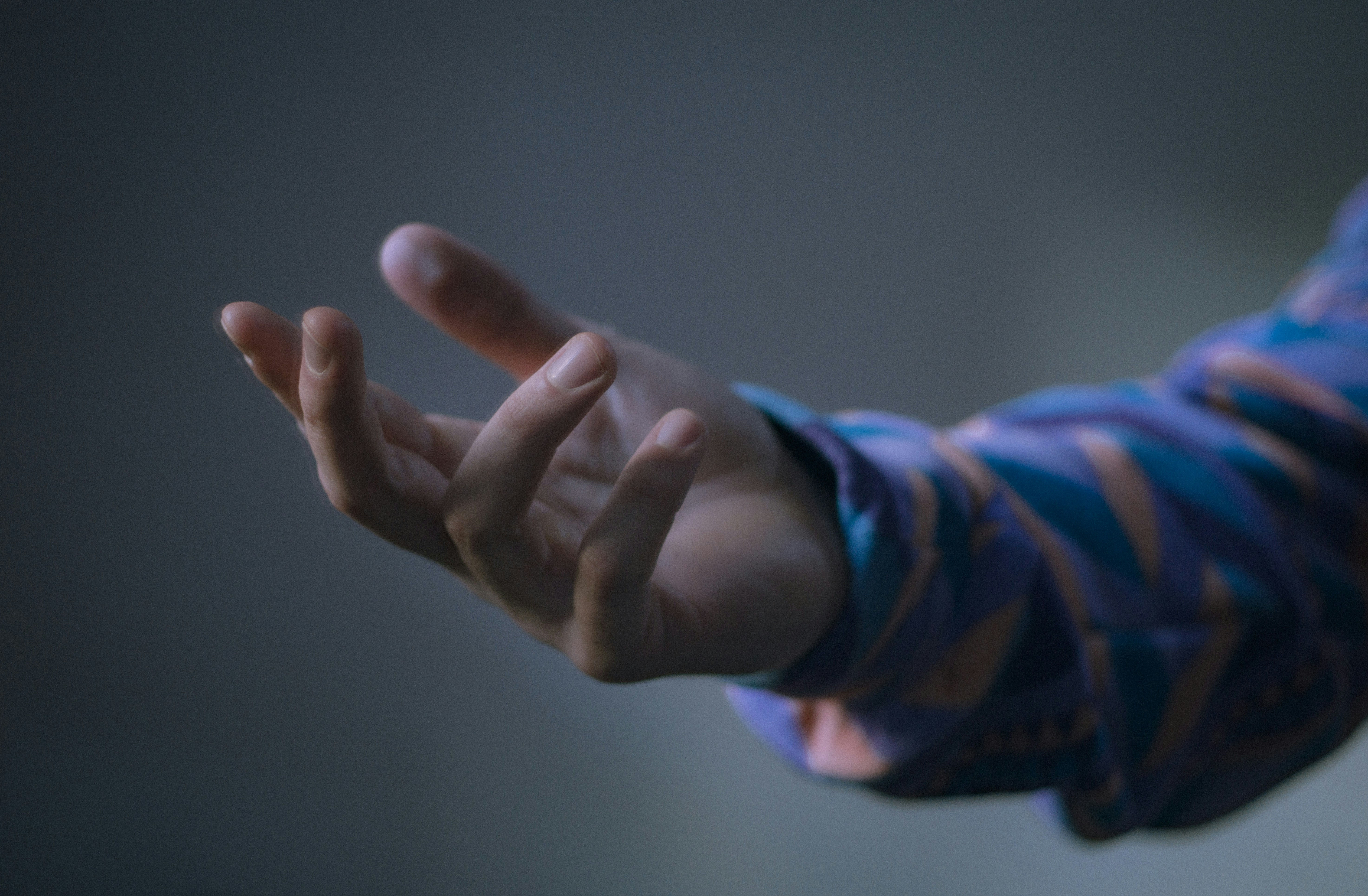 Eine ausgestreckte Hand greift nach vorne.