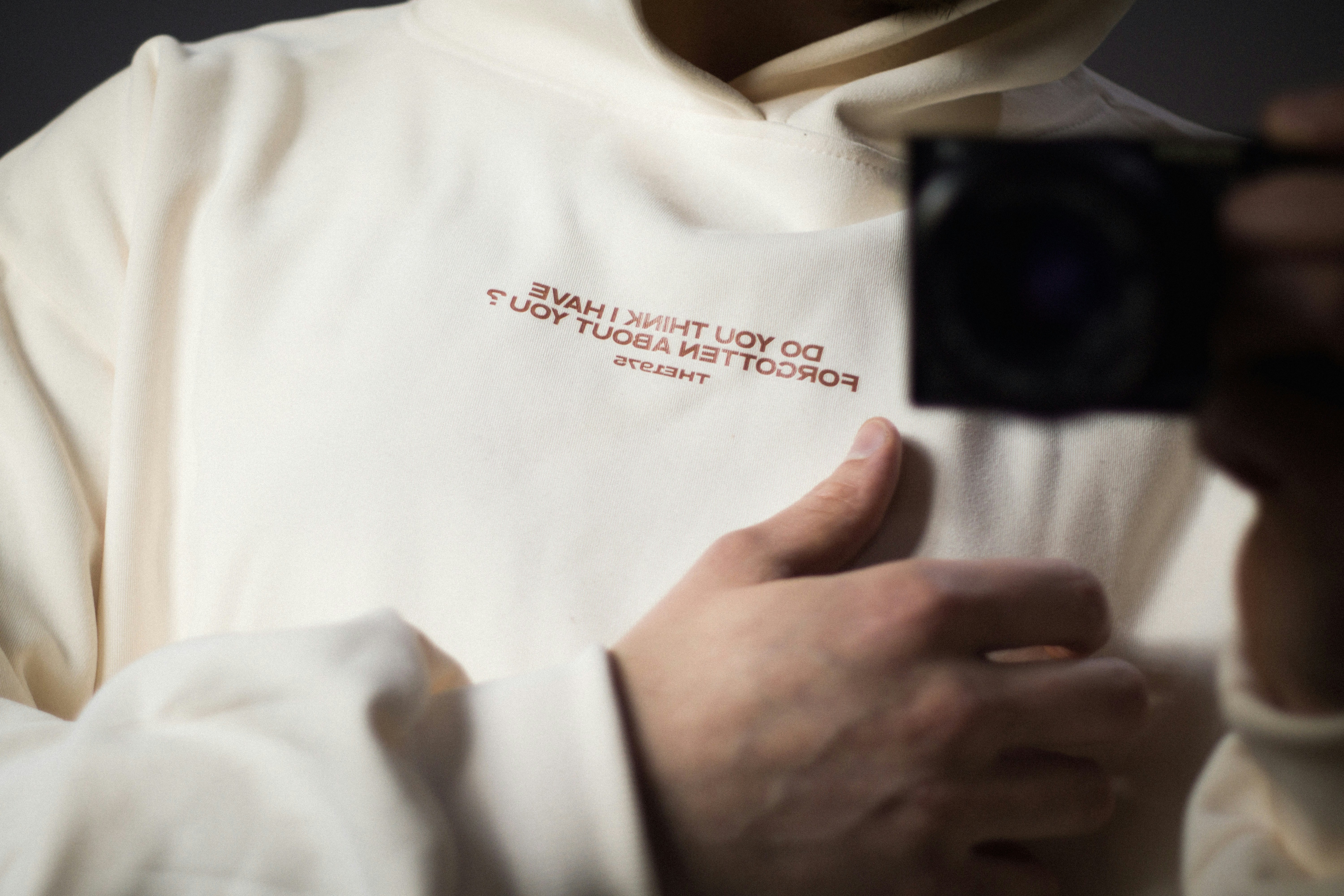 Cream hoodie with text and thumb