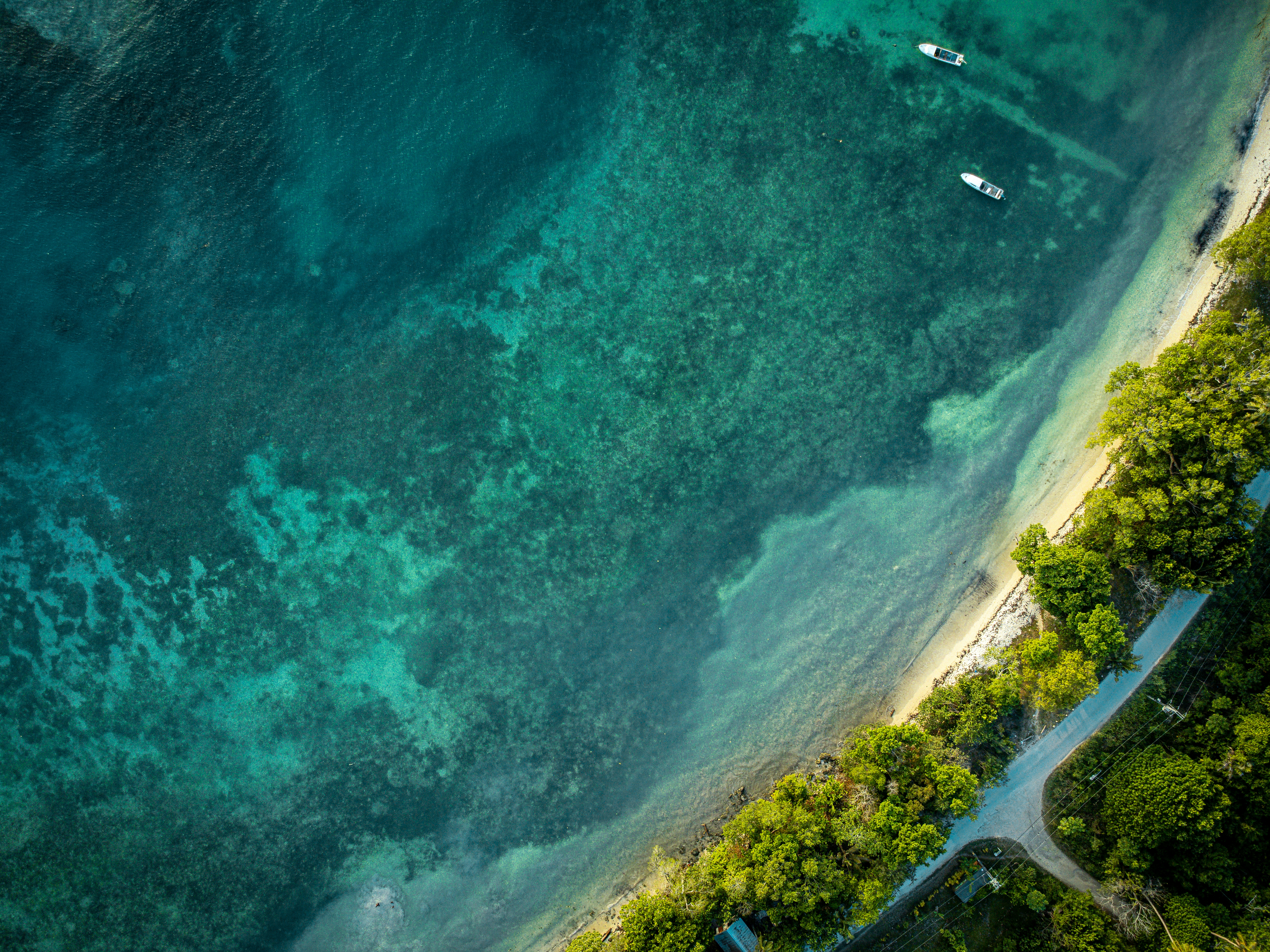 Aerial view of a tropical coastline with clear turquoise water.