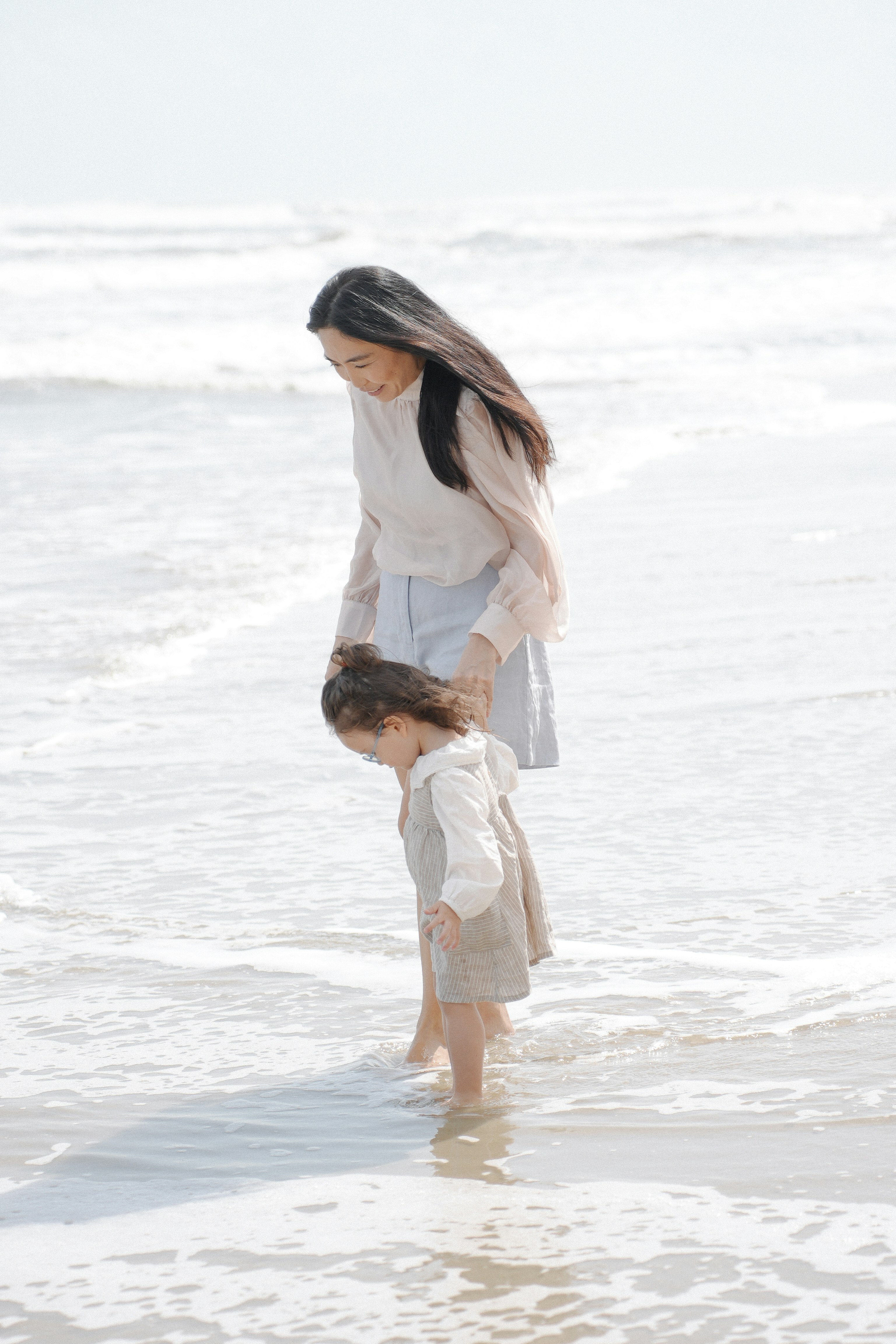 Mother and child playing at the ocean's edge