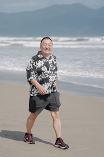 Smiling man walks on a sandy Wollongong beach healthy lifestyle and massage
