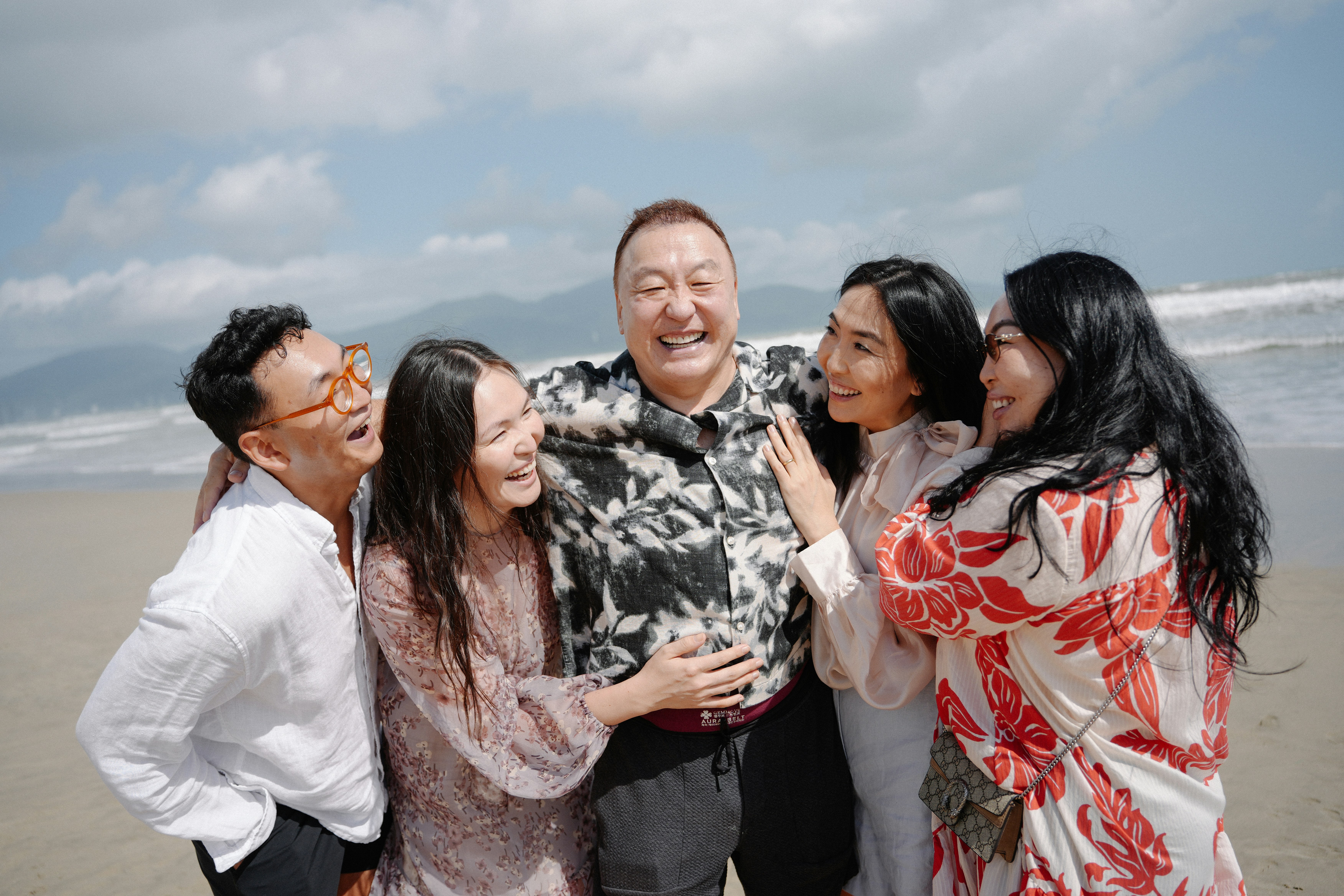 A happy family laughing together on a beach.