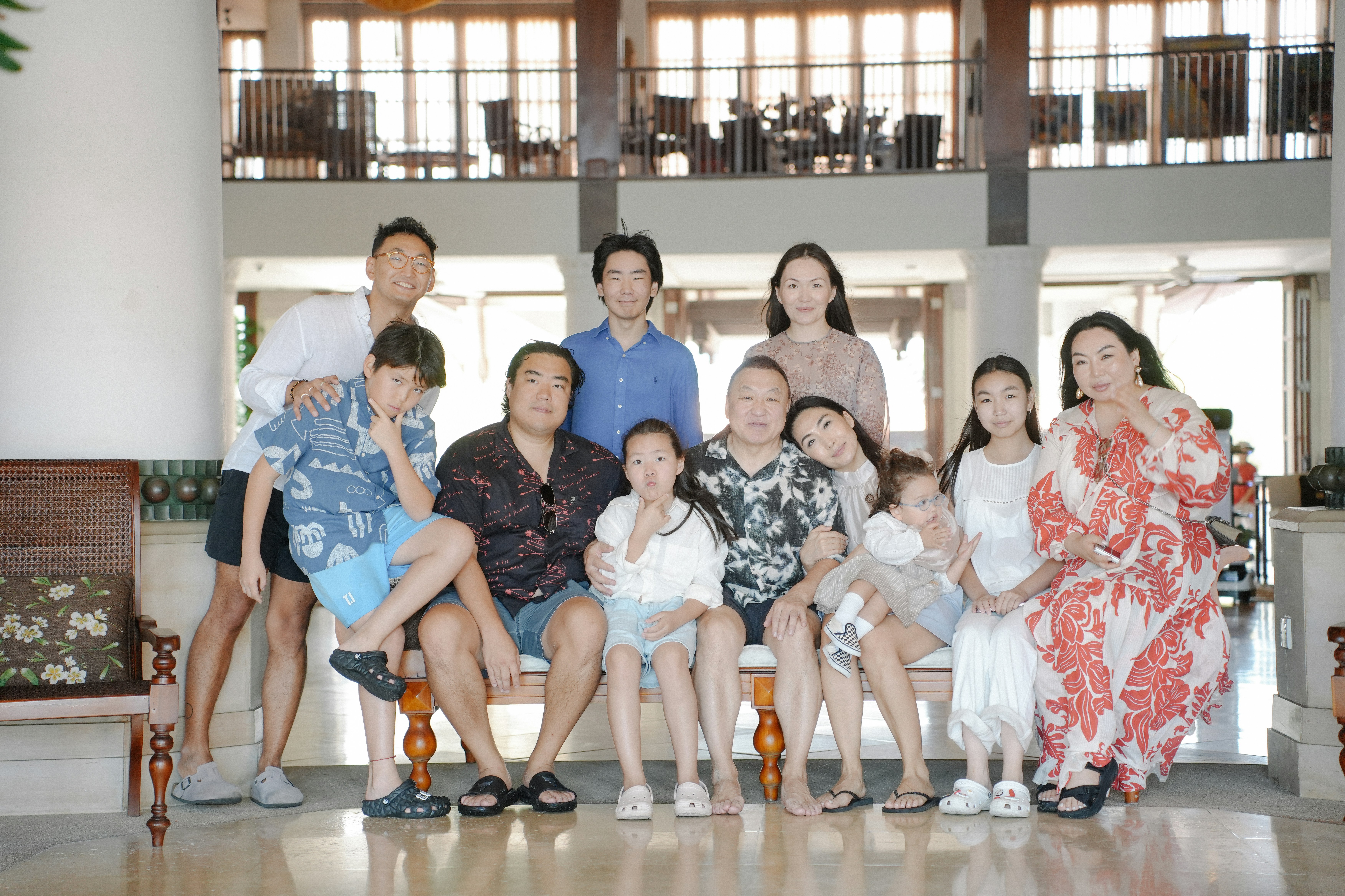 Una grande famiglia che posa per un ritratto di gruppo al chiuso.