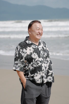 Smiling man in floral shirt on beach