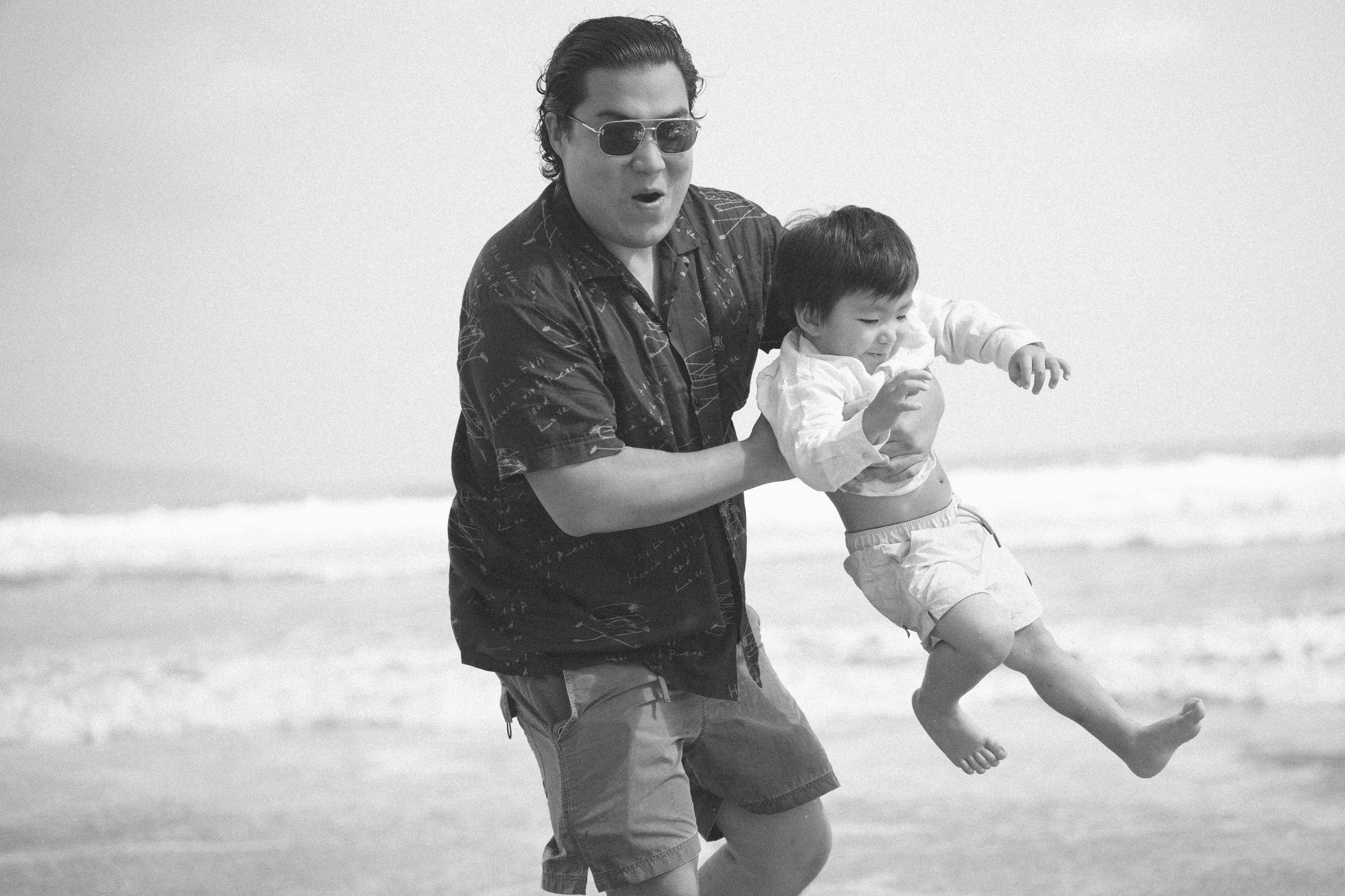 Man swinging a child at the beach