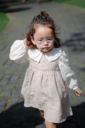 Young girl with glasses walking on a stone path