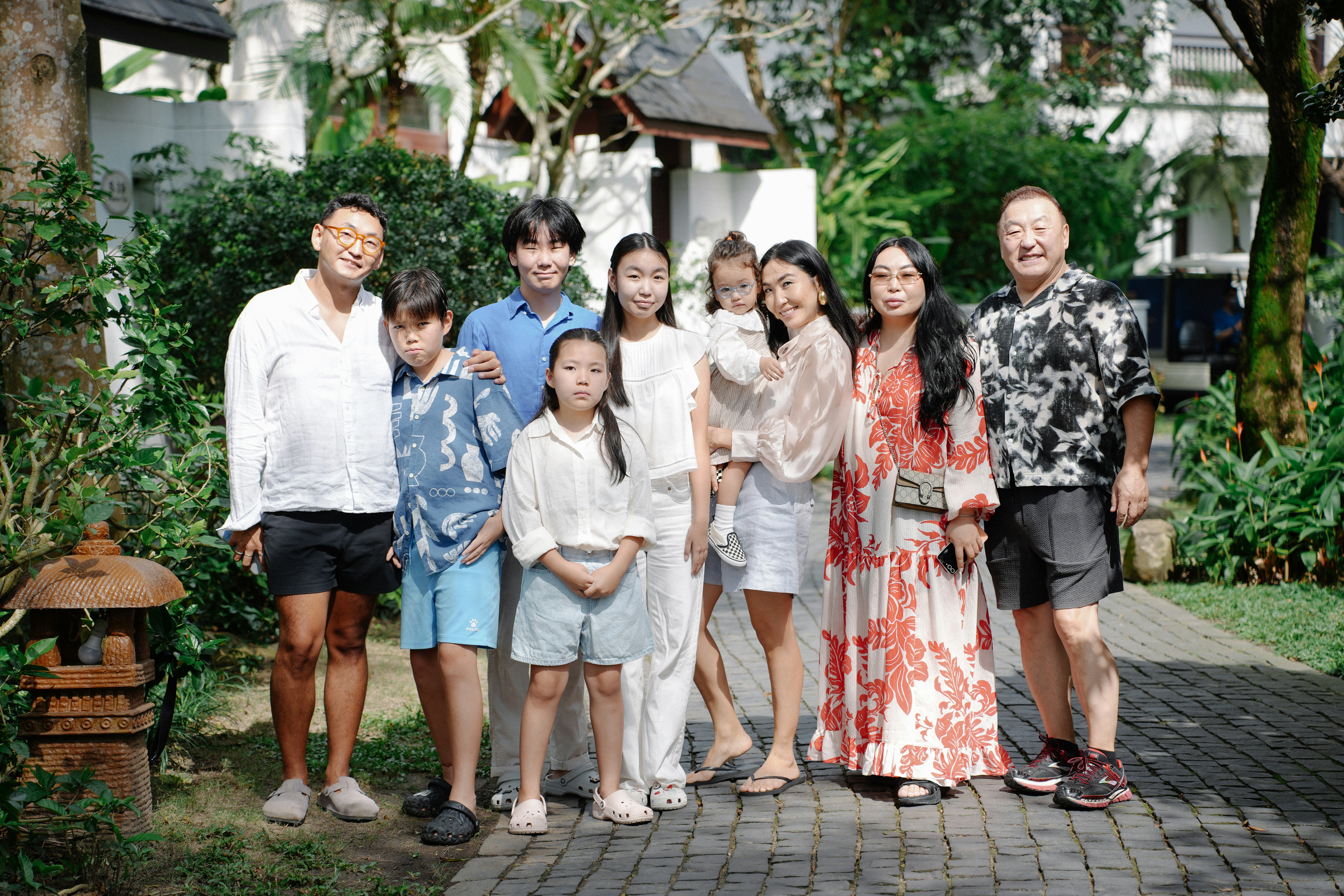 Una grande famiglia posa per un ritratto di gruppo all'aperto.