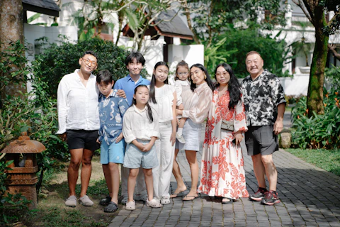A multi-generational family posing outdoors in a garden.