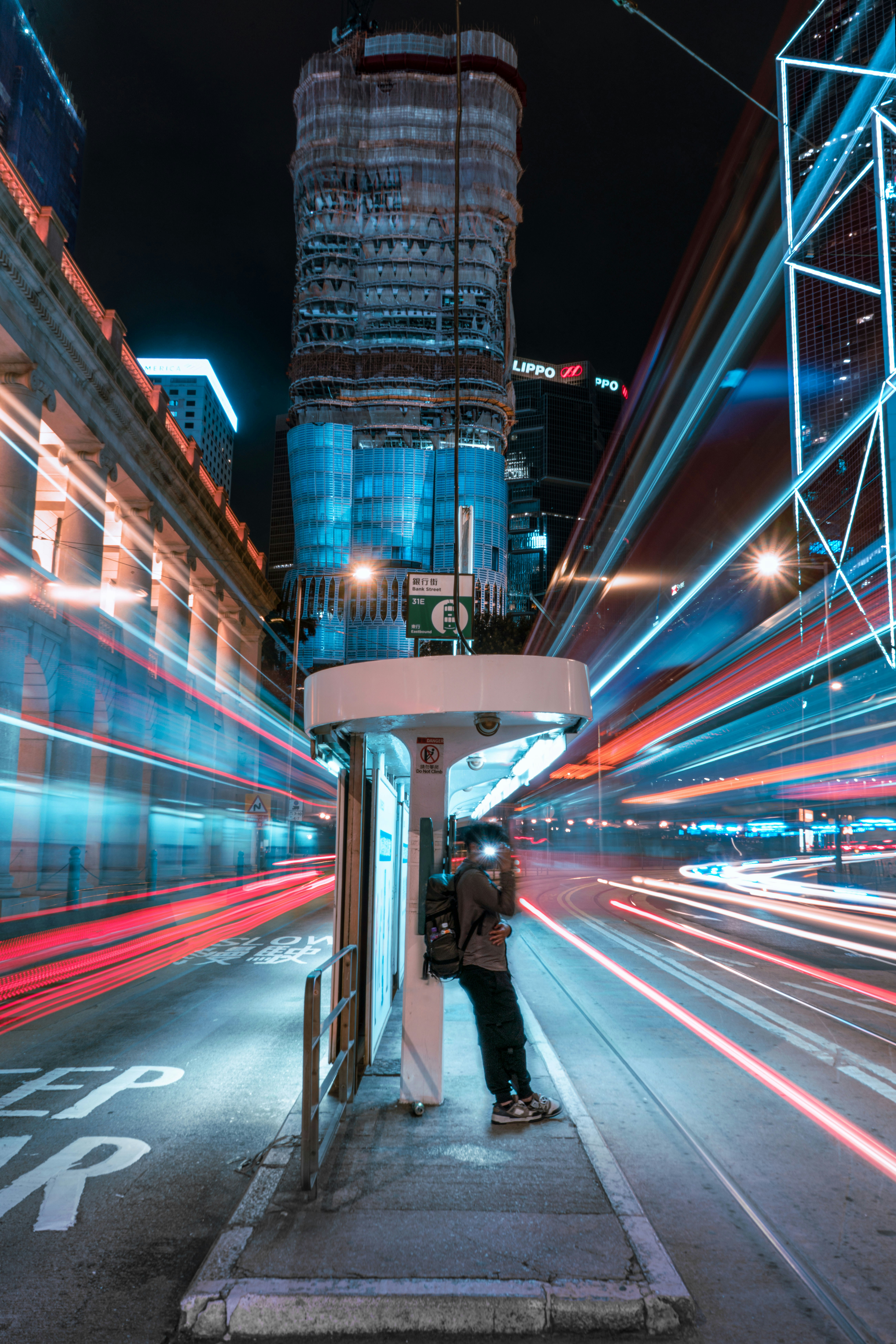 City street at night with light trails from vehicles.