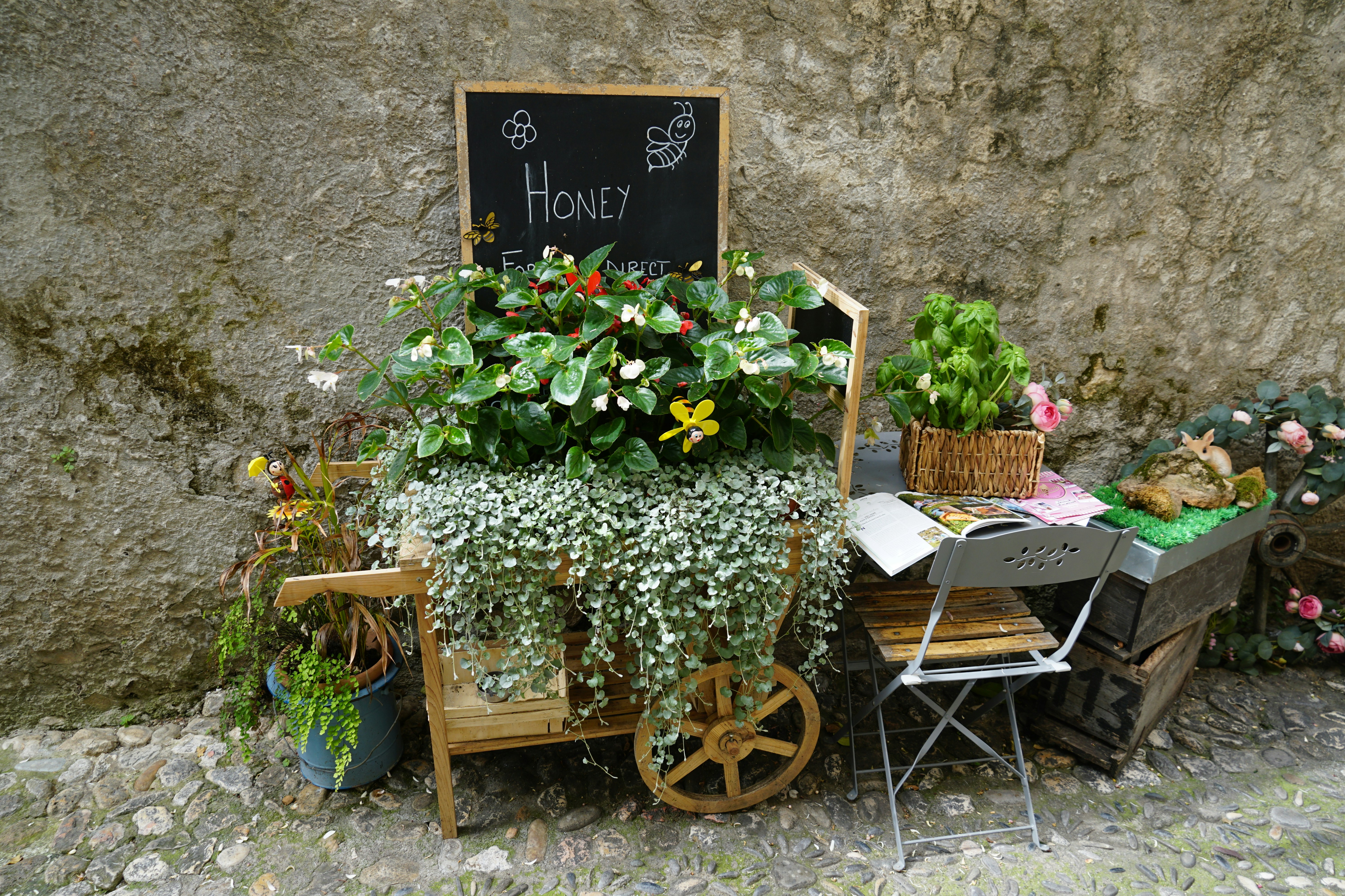 A small cart filled with plants and flowers.