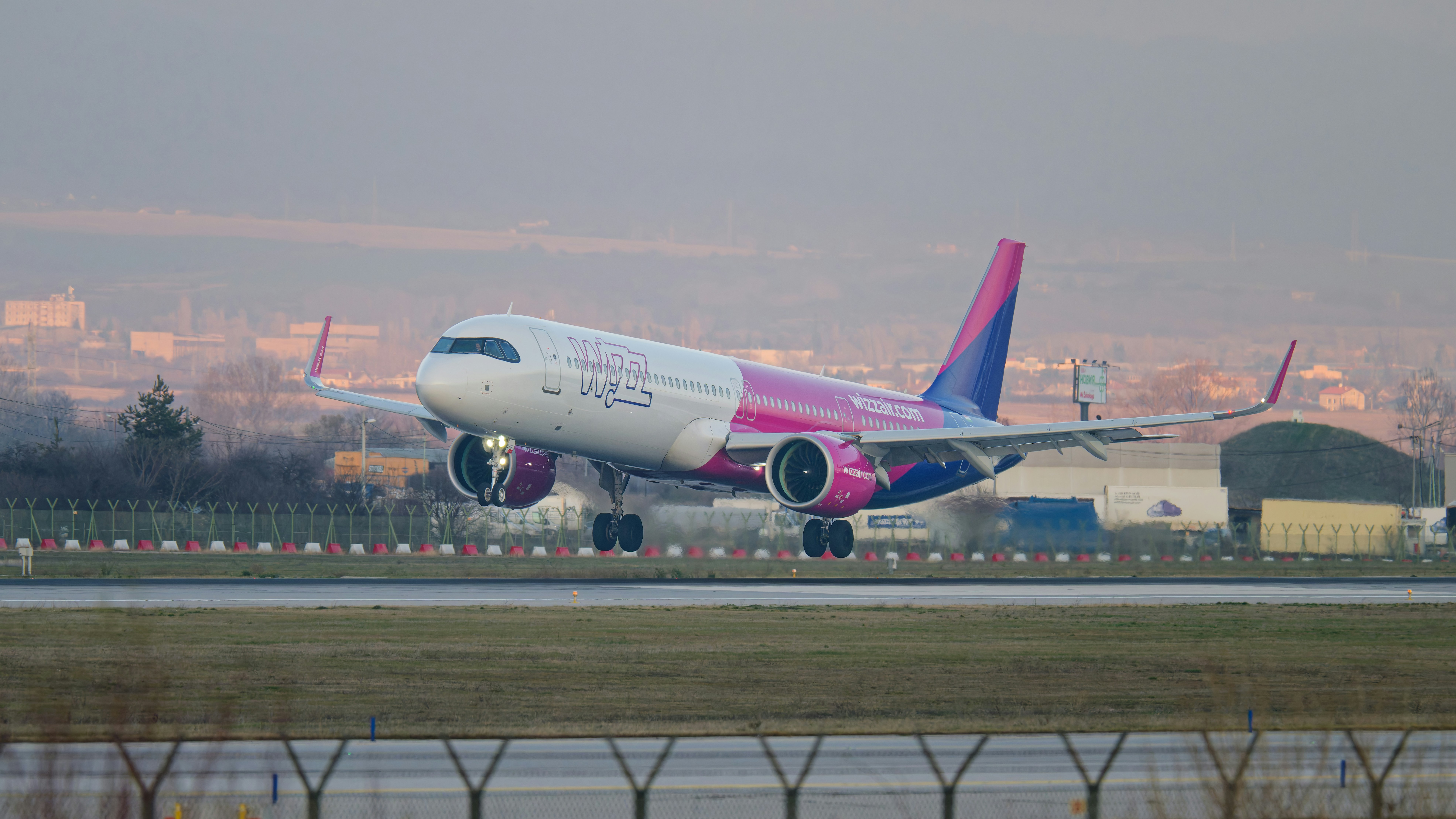 Airplane taking off on a runway with city in background